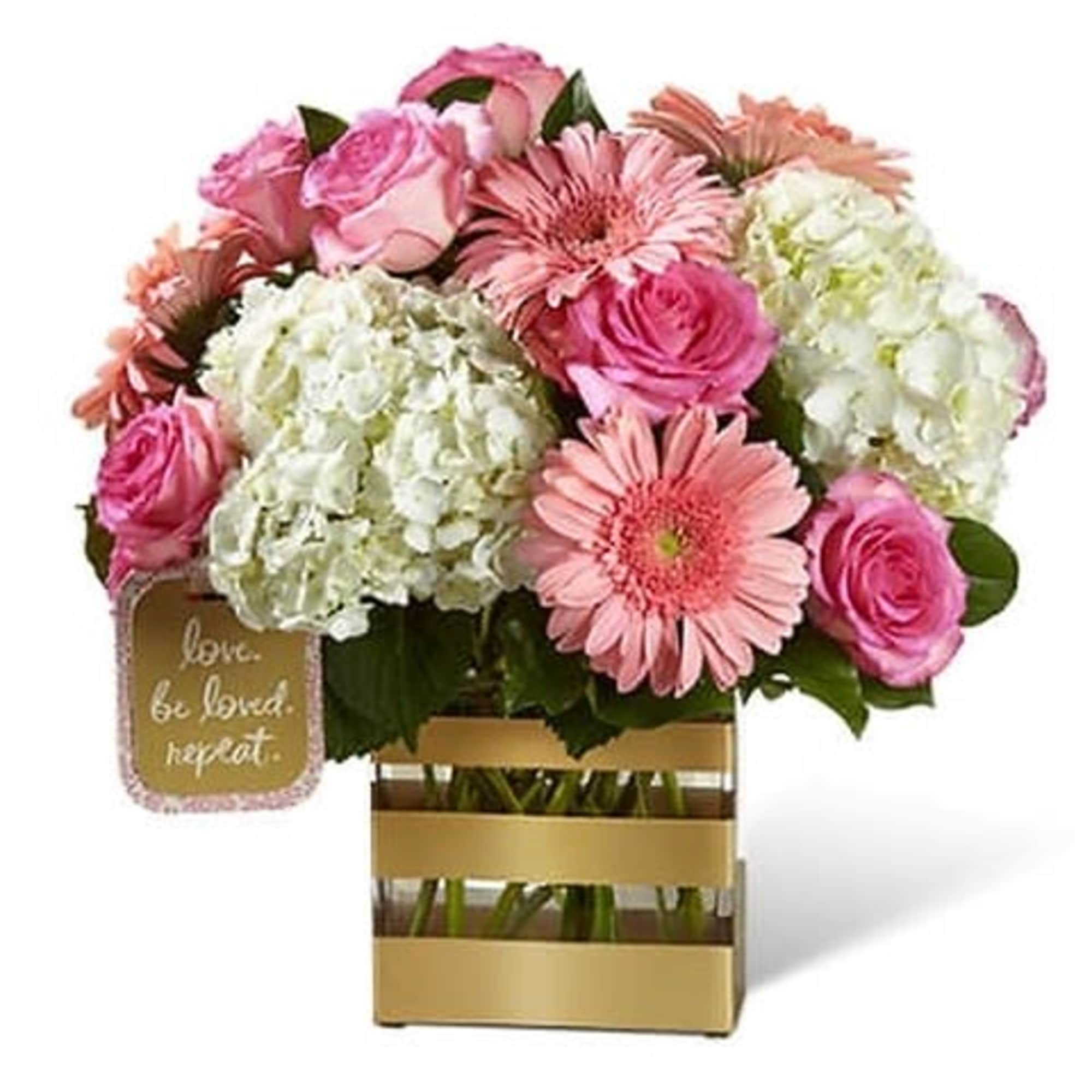 Bringing together pink roses and pink gerbera daisies, surrounded by clouds of