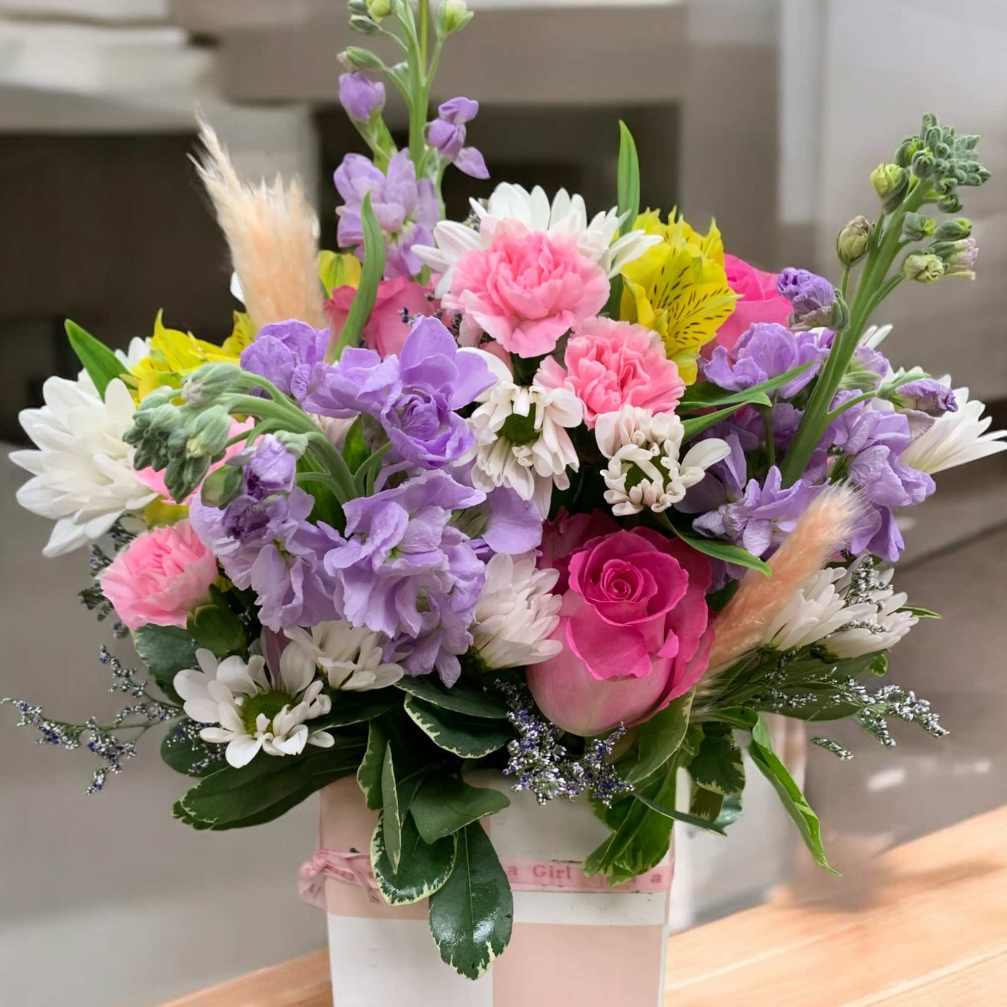 Soft, feminine and cheerful. This lovely combination of stock, roses and beautiful