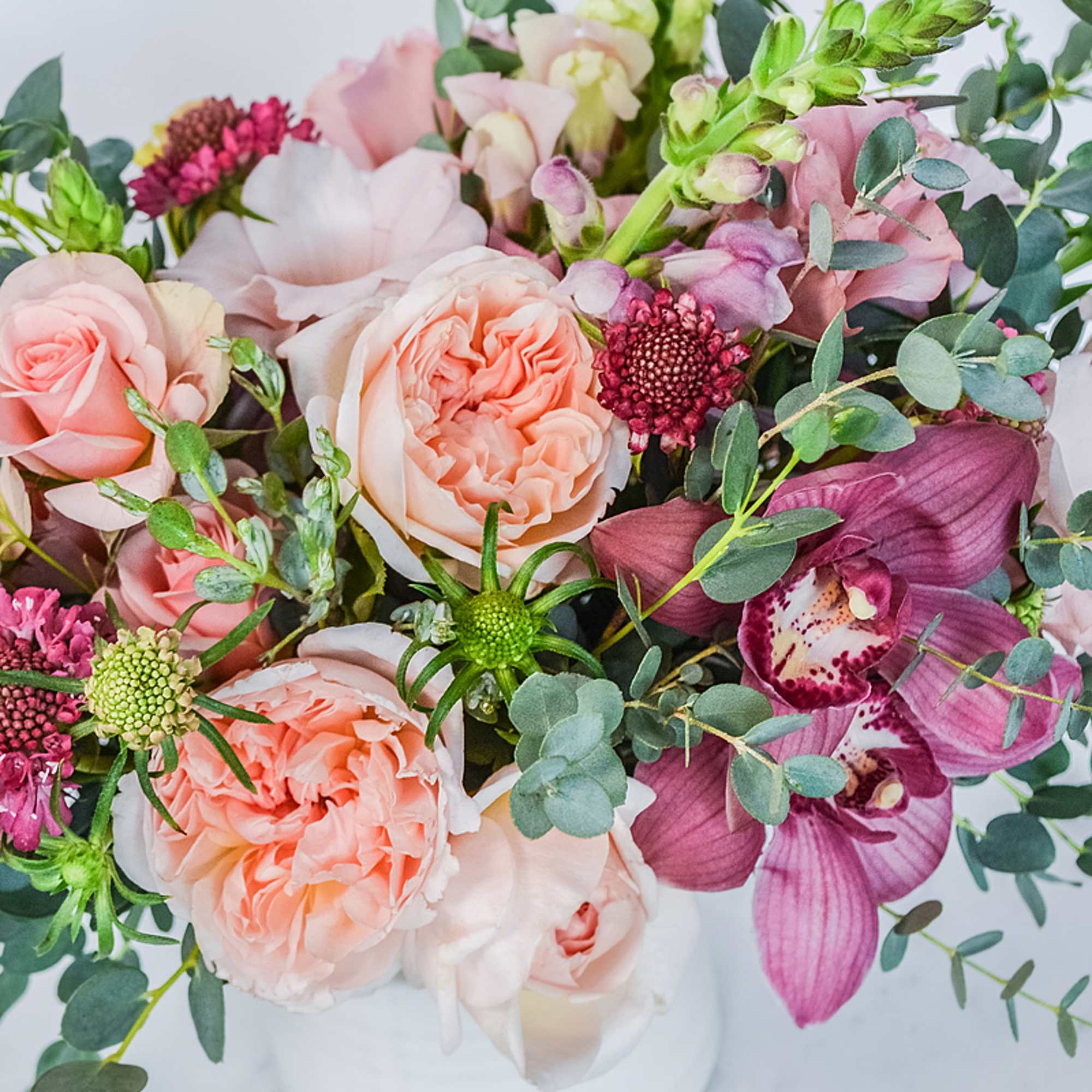 Bouquet of blush roses and purple orchids with eucalyptus