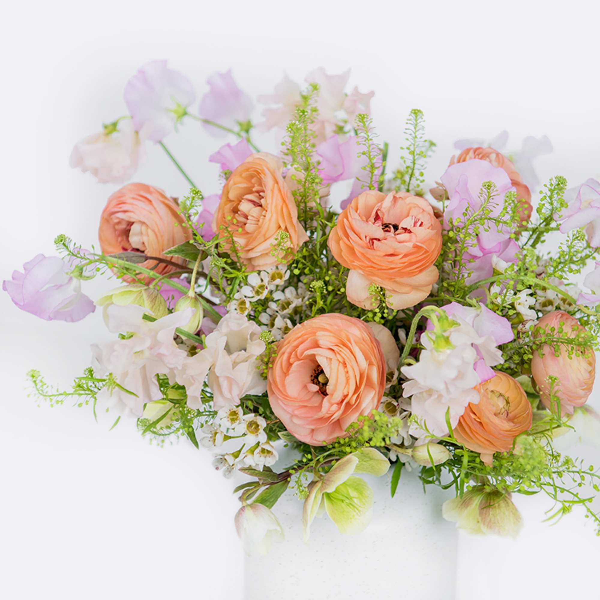 Peach and lavender floral arrangement in a white vase