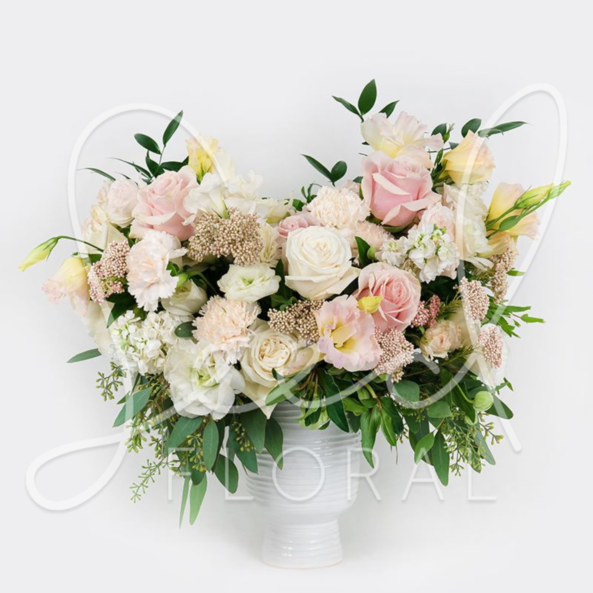 Blush and white rose arrangement in a white vase