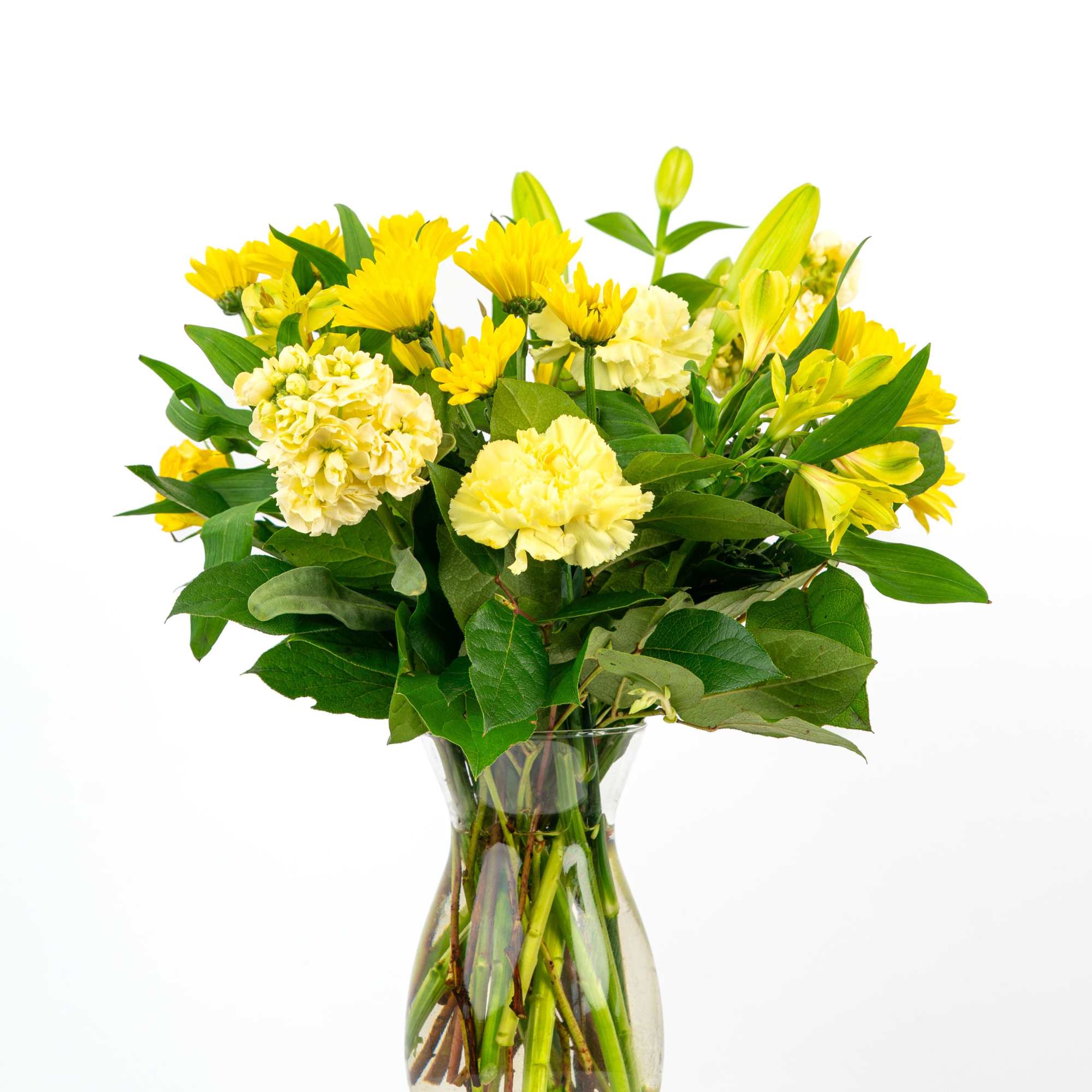 Yellow carnations, chrysanthemums, and lilies arranged in a clear glass vase