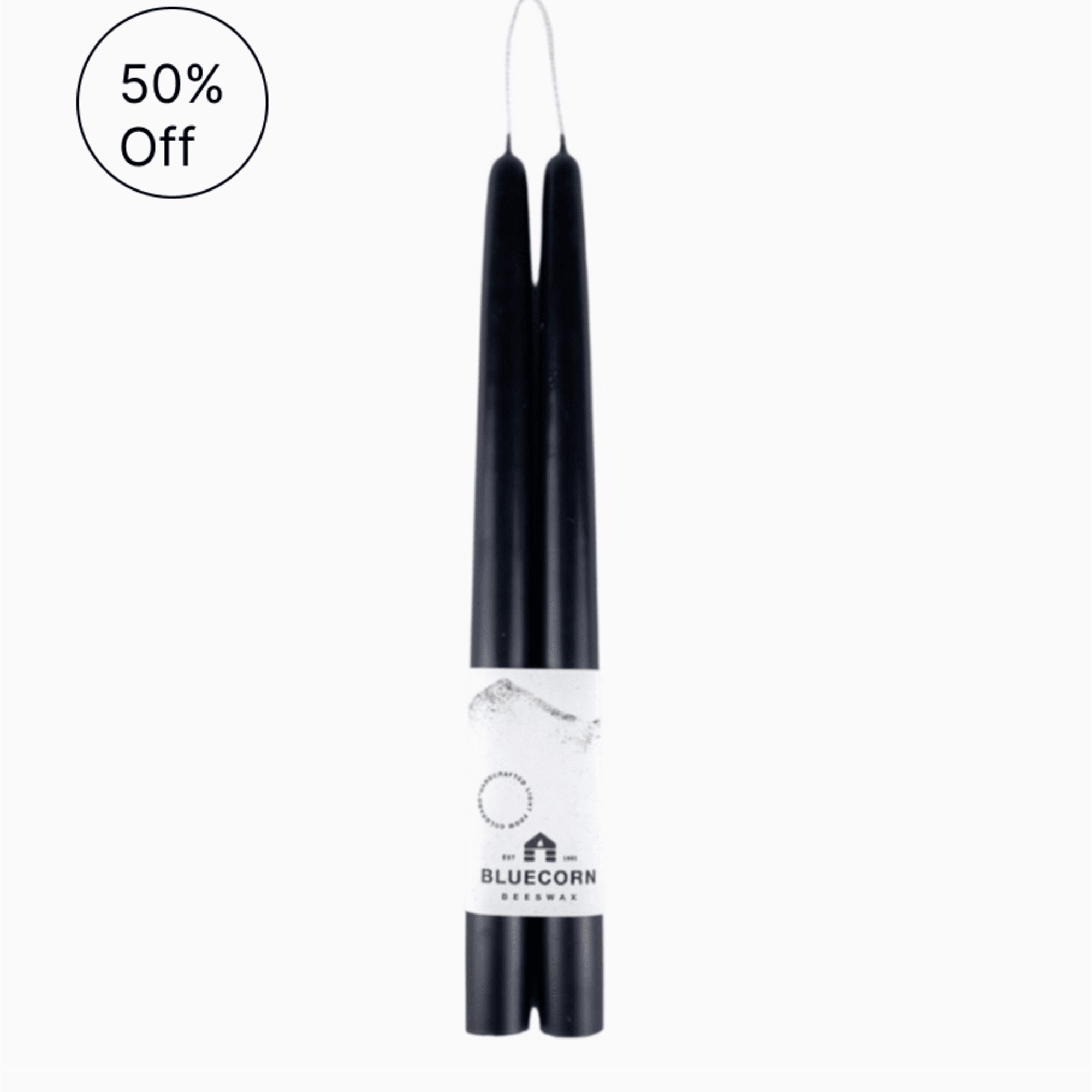 Pair of black taper candles joined by one wick with a Bluecorn label around the base
