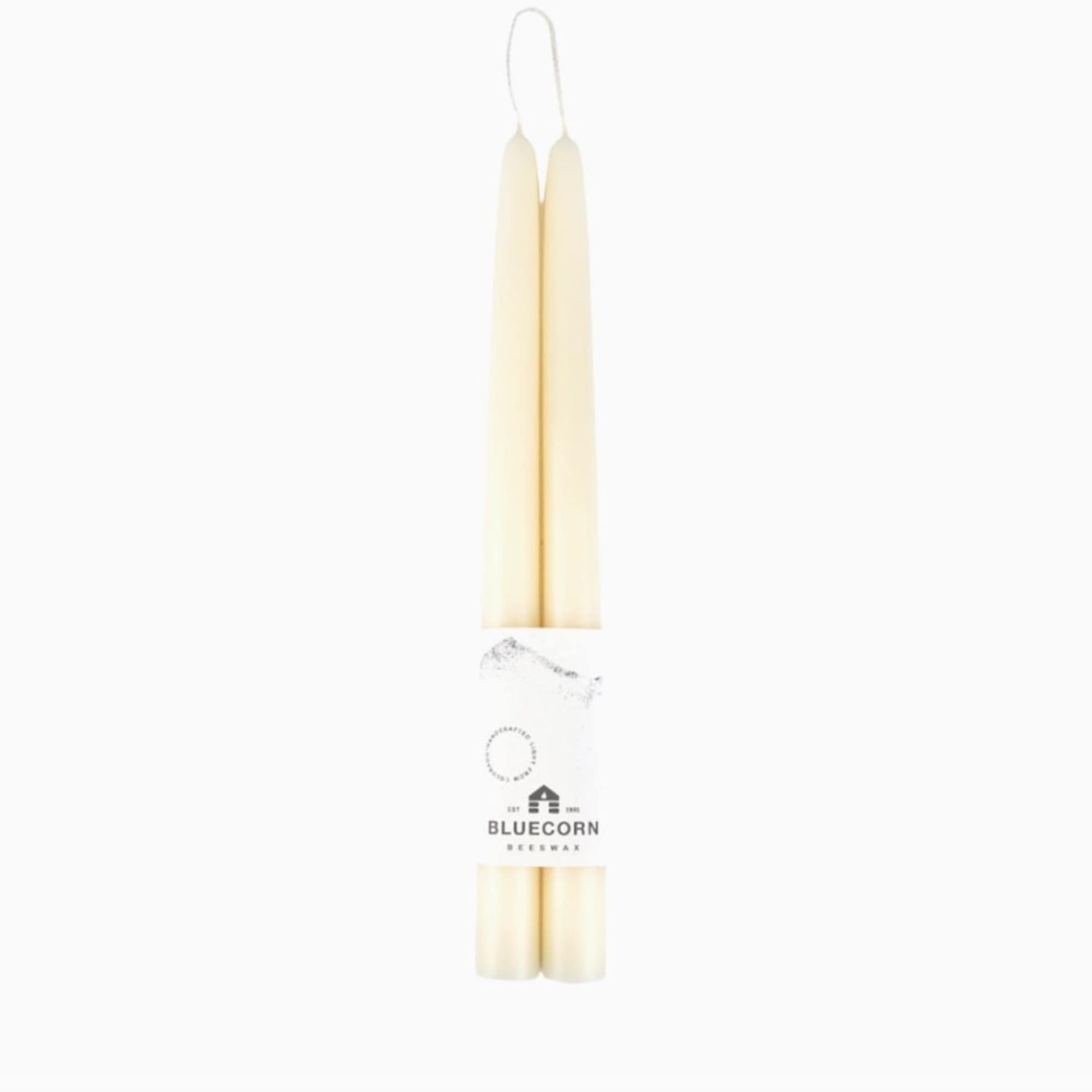 Pair of ivory taper candles bundled with a white Bluecorn Beeswax label on a white background