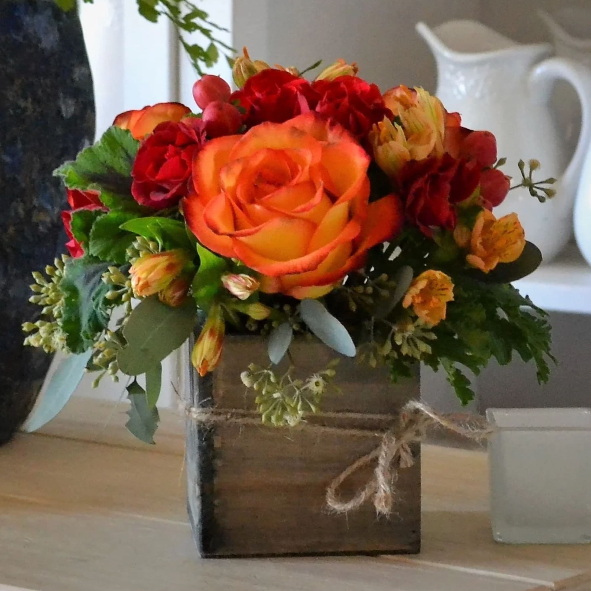 Orange and red rose bouquet in a wooden box