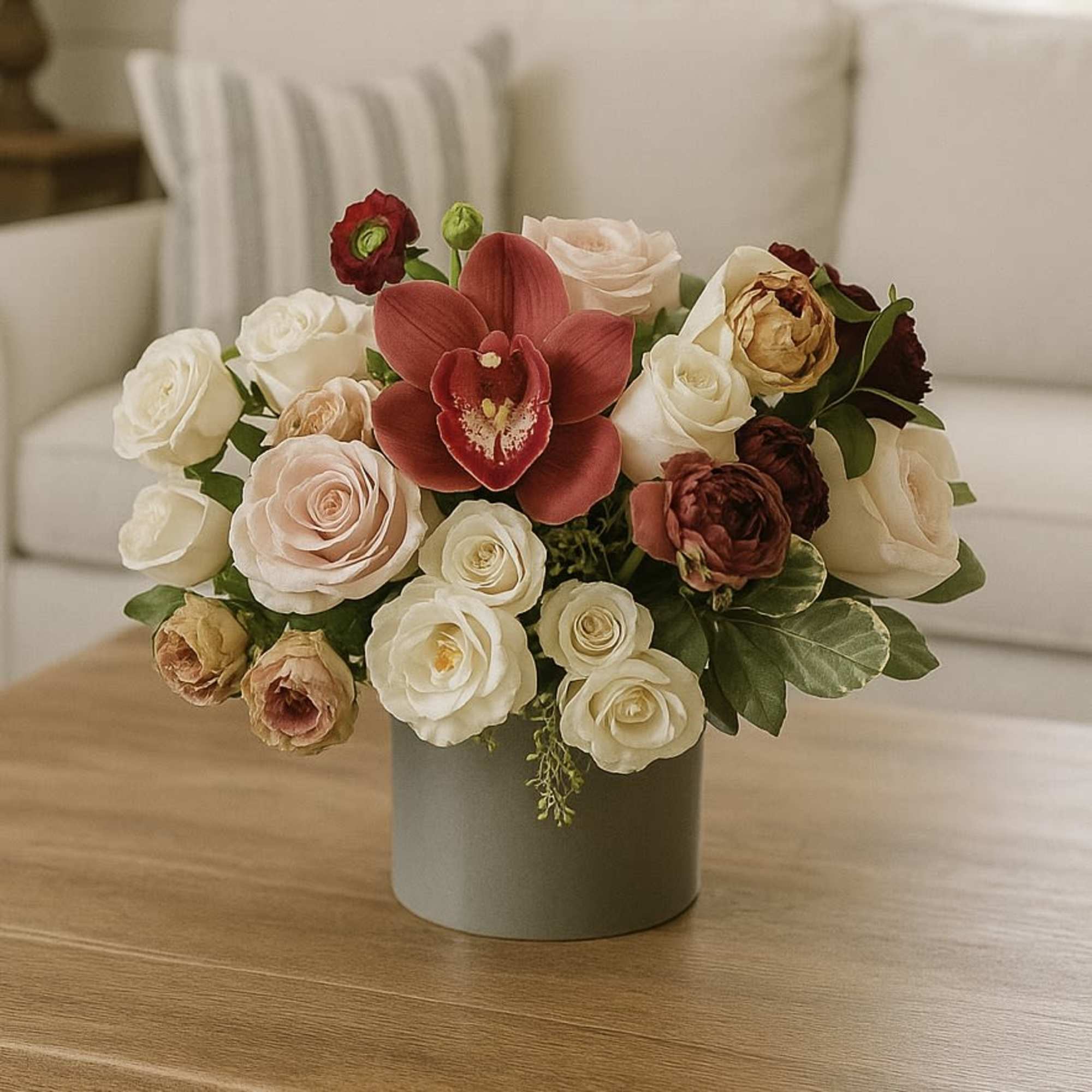 Bouquet of roses and red orchids in a gray vase
