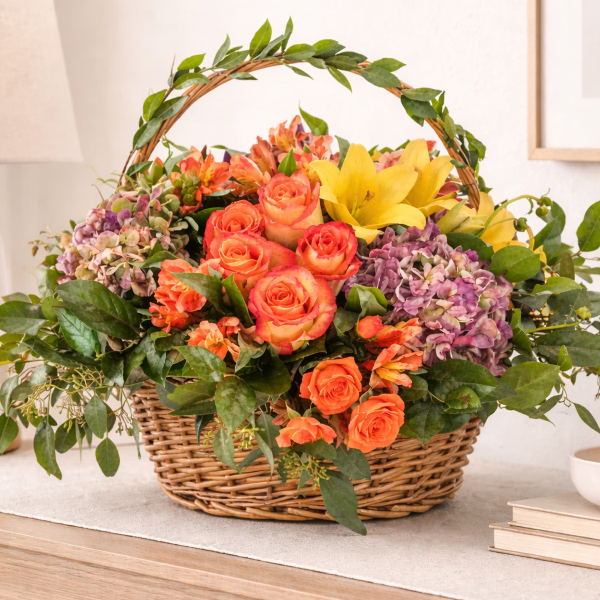 Basket of orange roses, yellow lilies, and purple hydrangeas