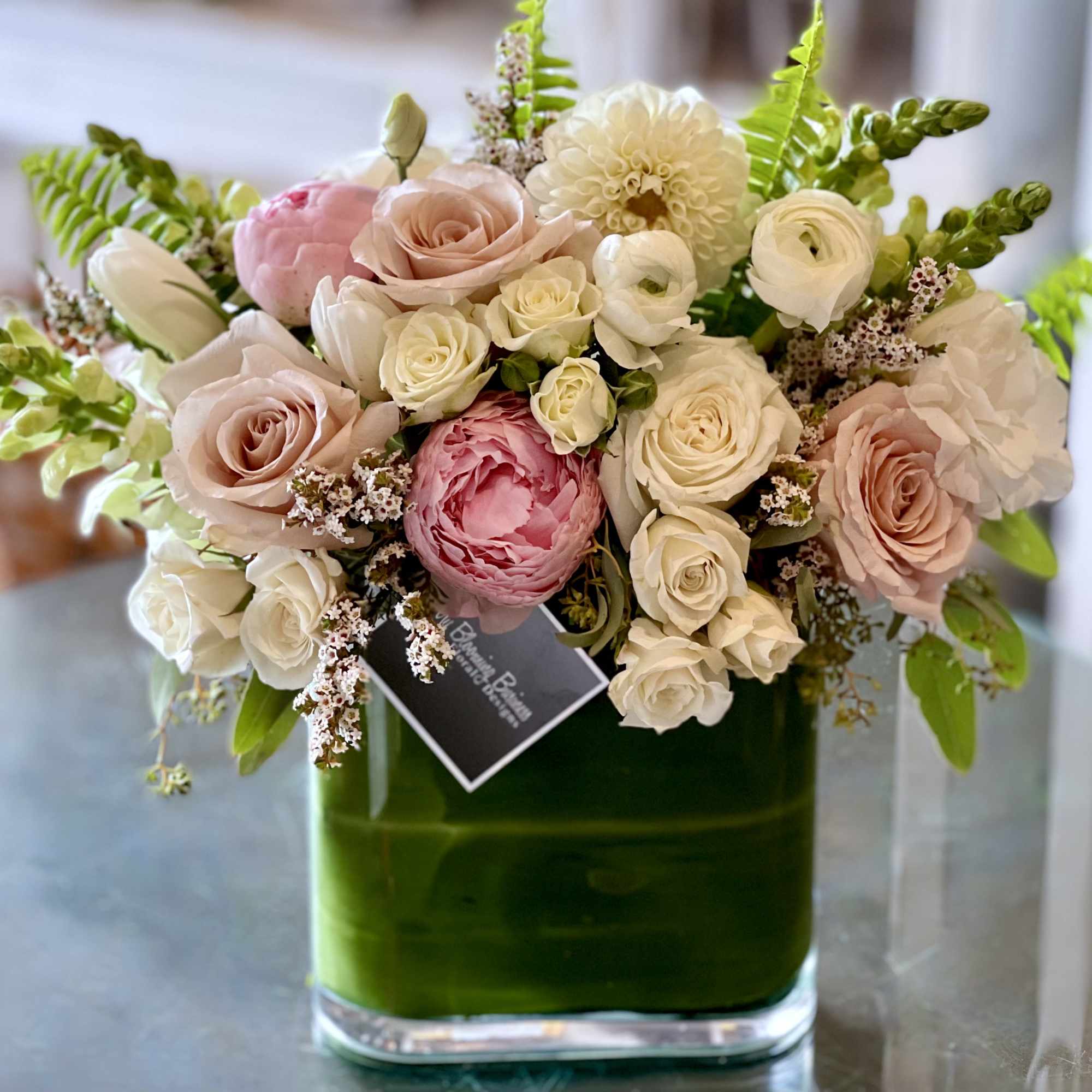 Pink and white roses in a green glass vase