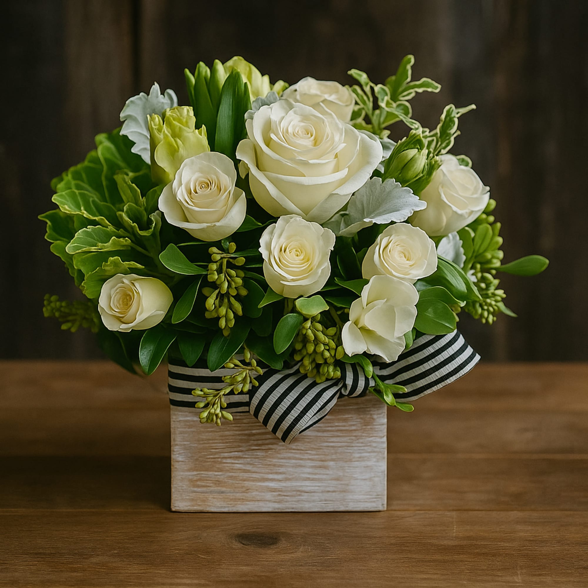 White roses in a square wooden box with a striped ribbon
