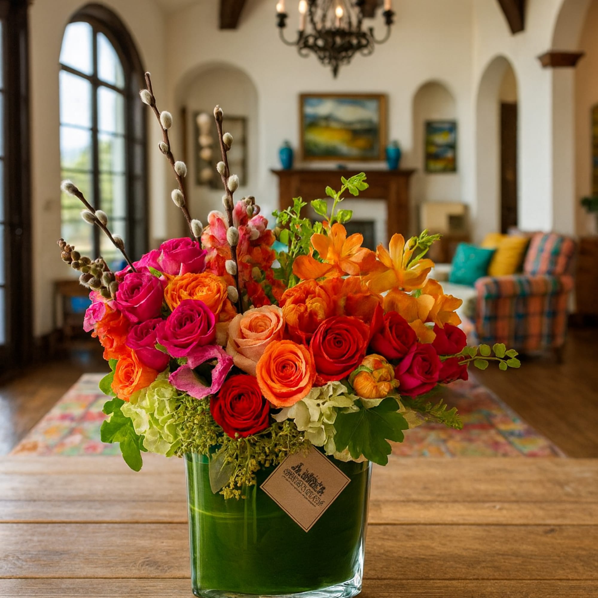 Bright mixed rose arrangement in a green glass vase