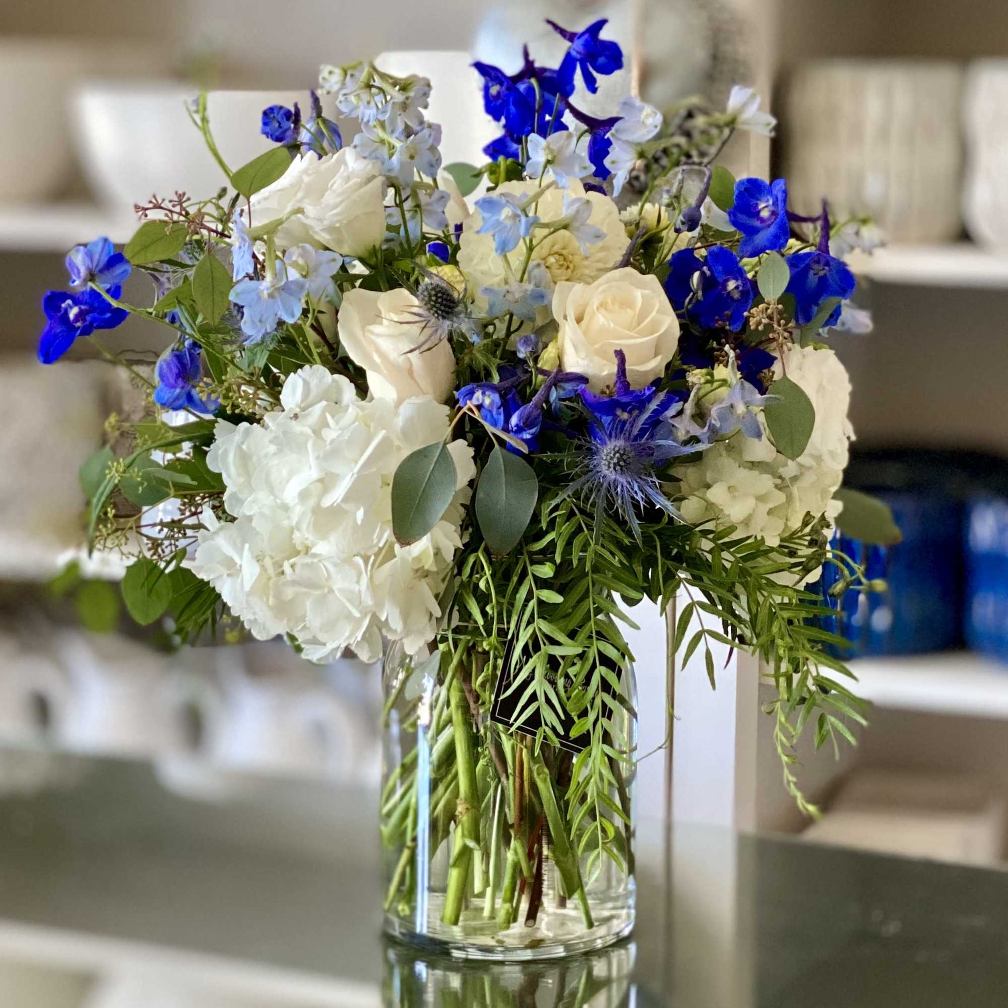 Blue and white mixed bouquet in a clear glass vase