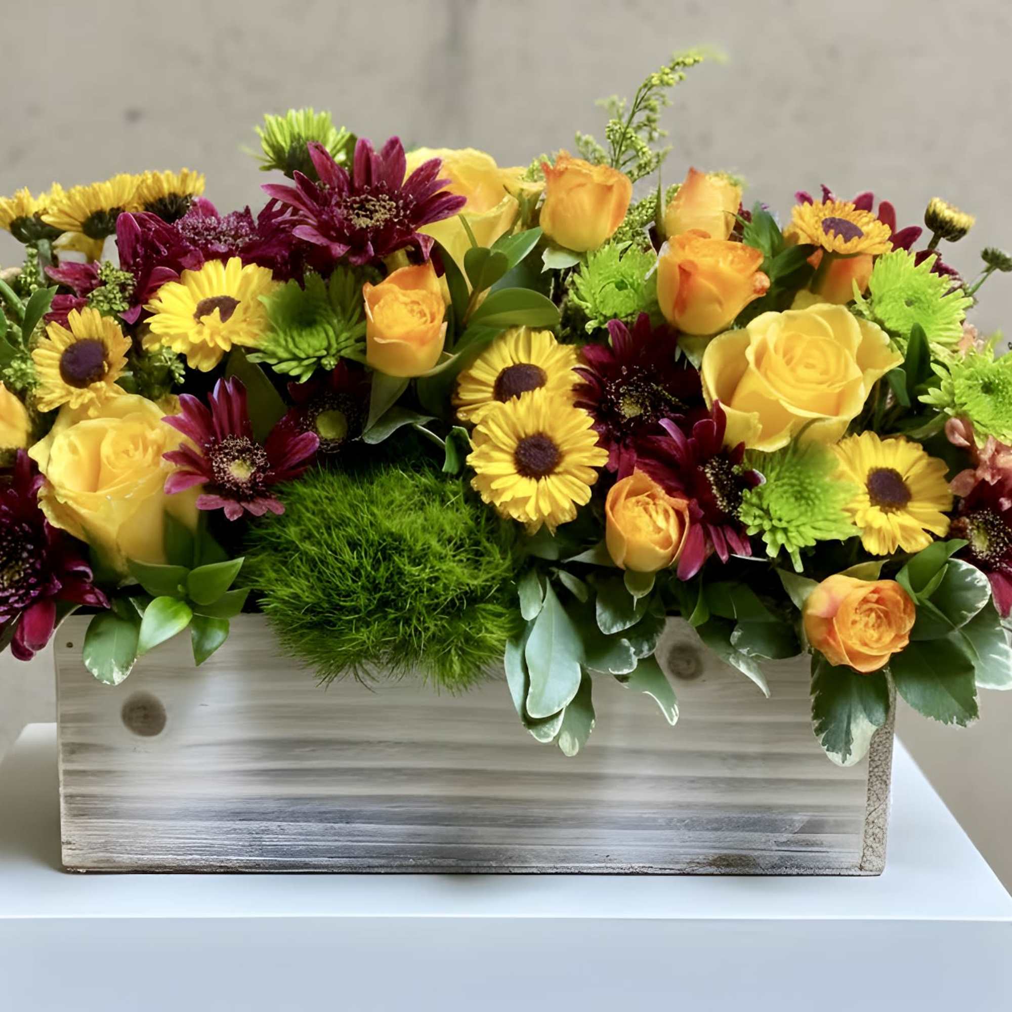 Yellow roses and burgundy daisies in a wooden box