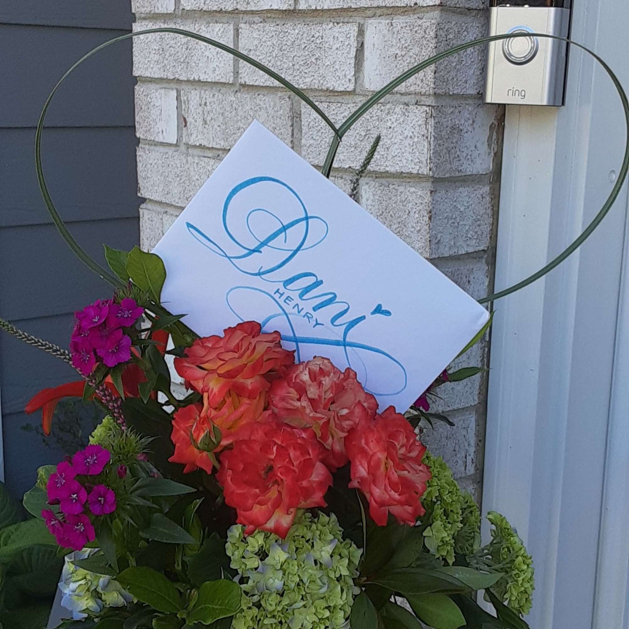 Mixed bouquet of coral roses and green hydrangeas in a glass vase