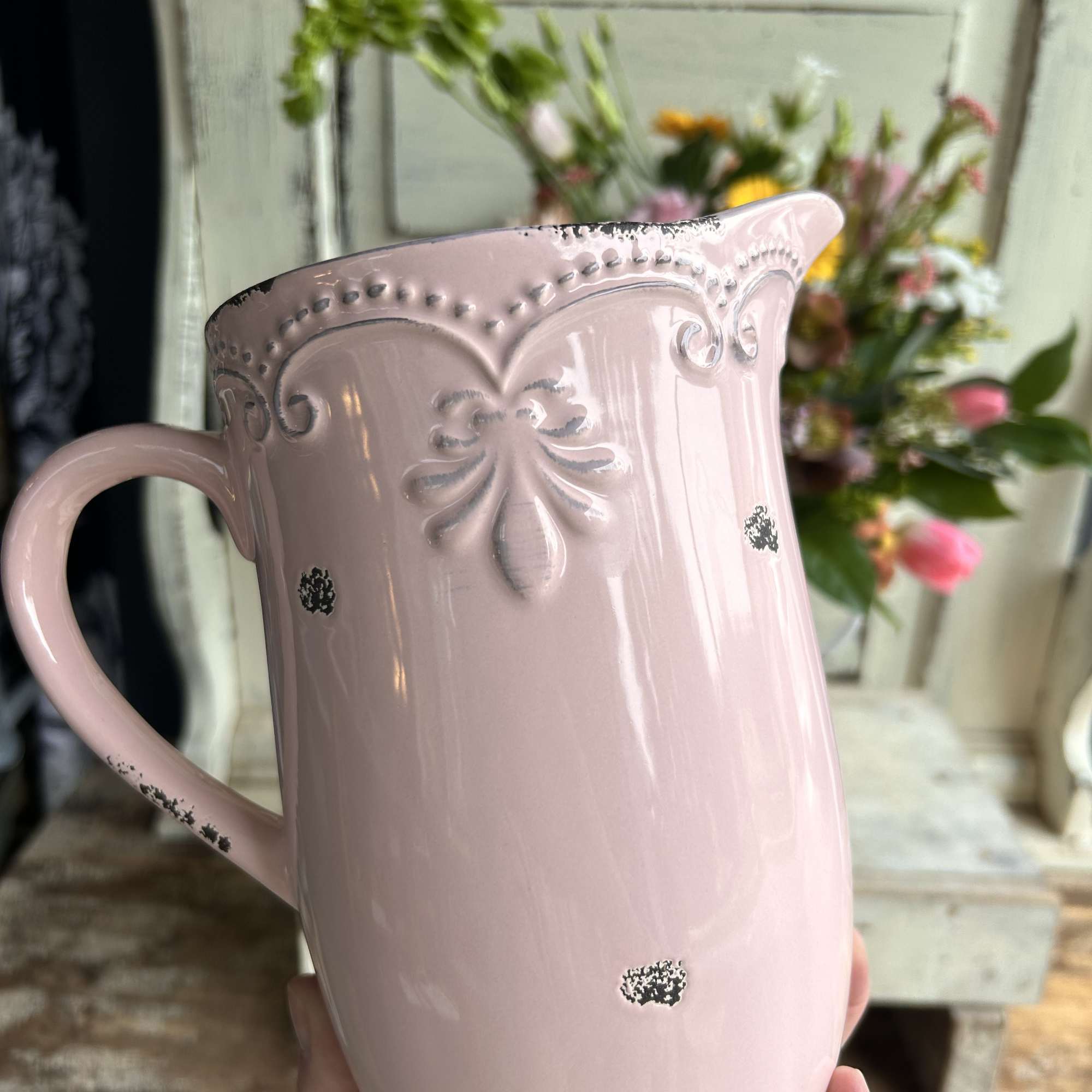 A charming arrangement of seasonal flowers, fillers and foliage in a ceramic