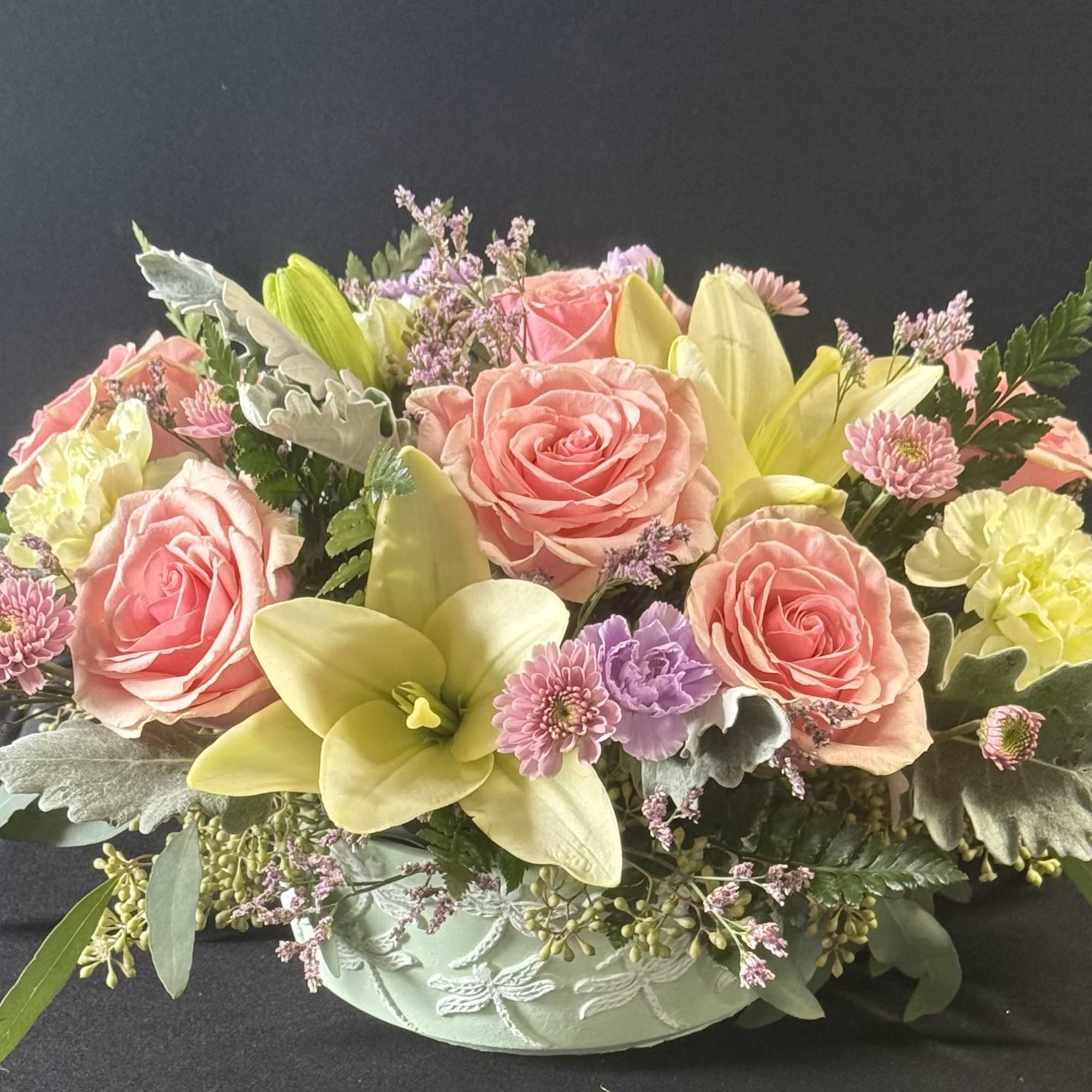 Pastel flowers in a mint green ceramic dragonfly container