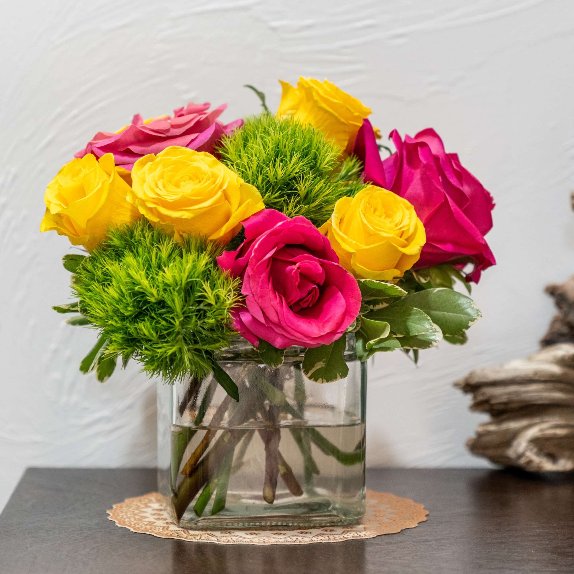 Pink and yellow roses in a clear glass vase