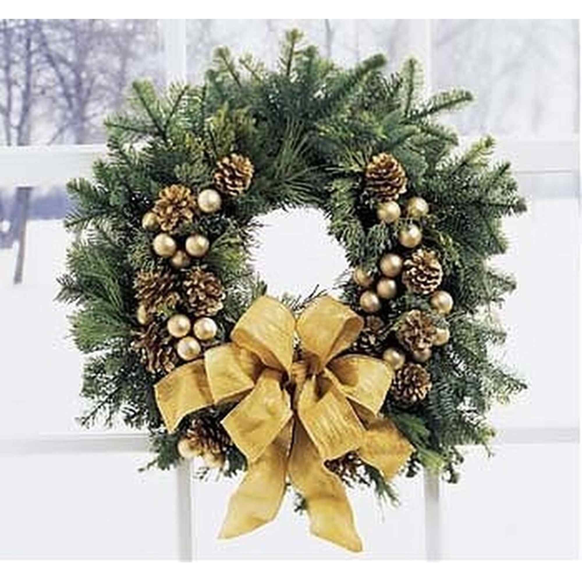 Evergreen wreath with gold pine cones, ornaments, and a large gold bow hanging on a window