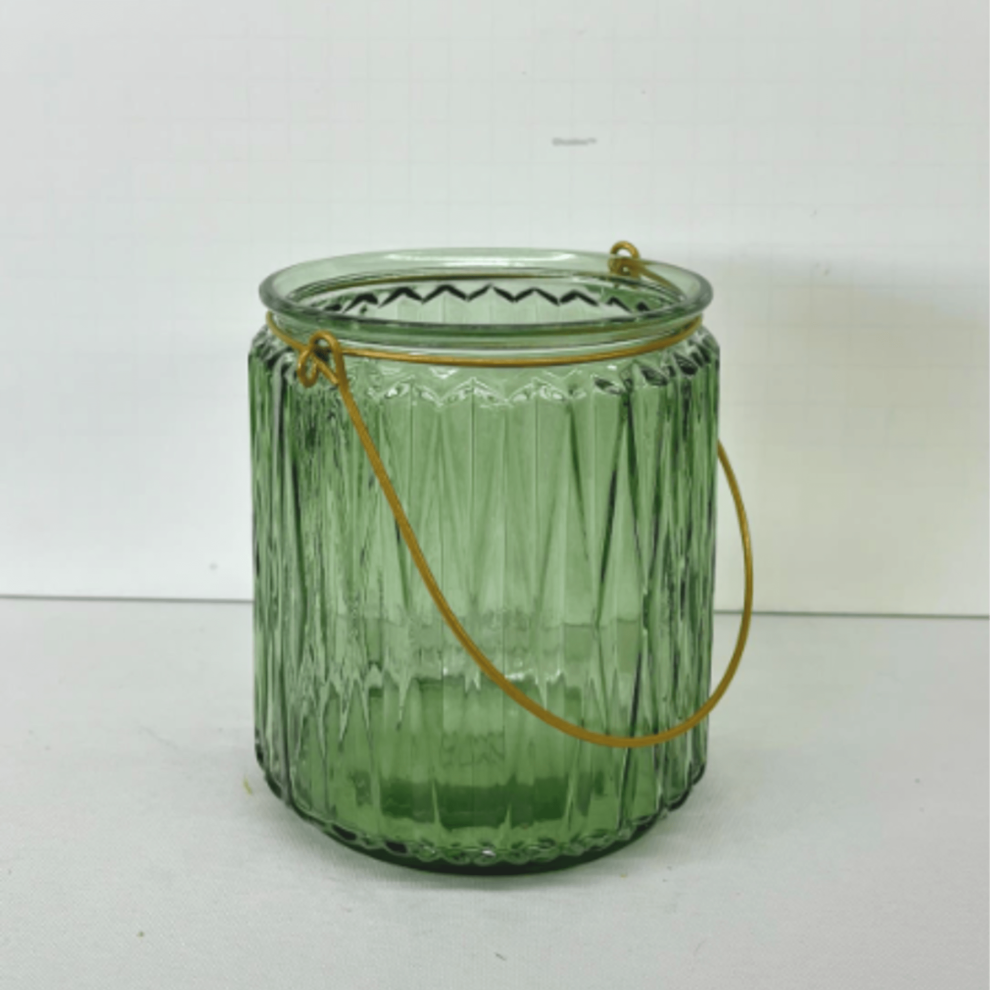 Green glass candle holder with a metal handle
