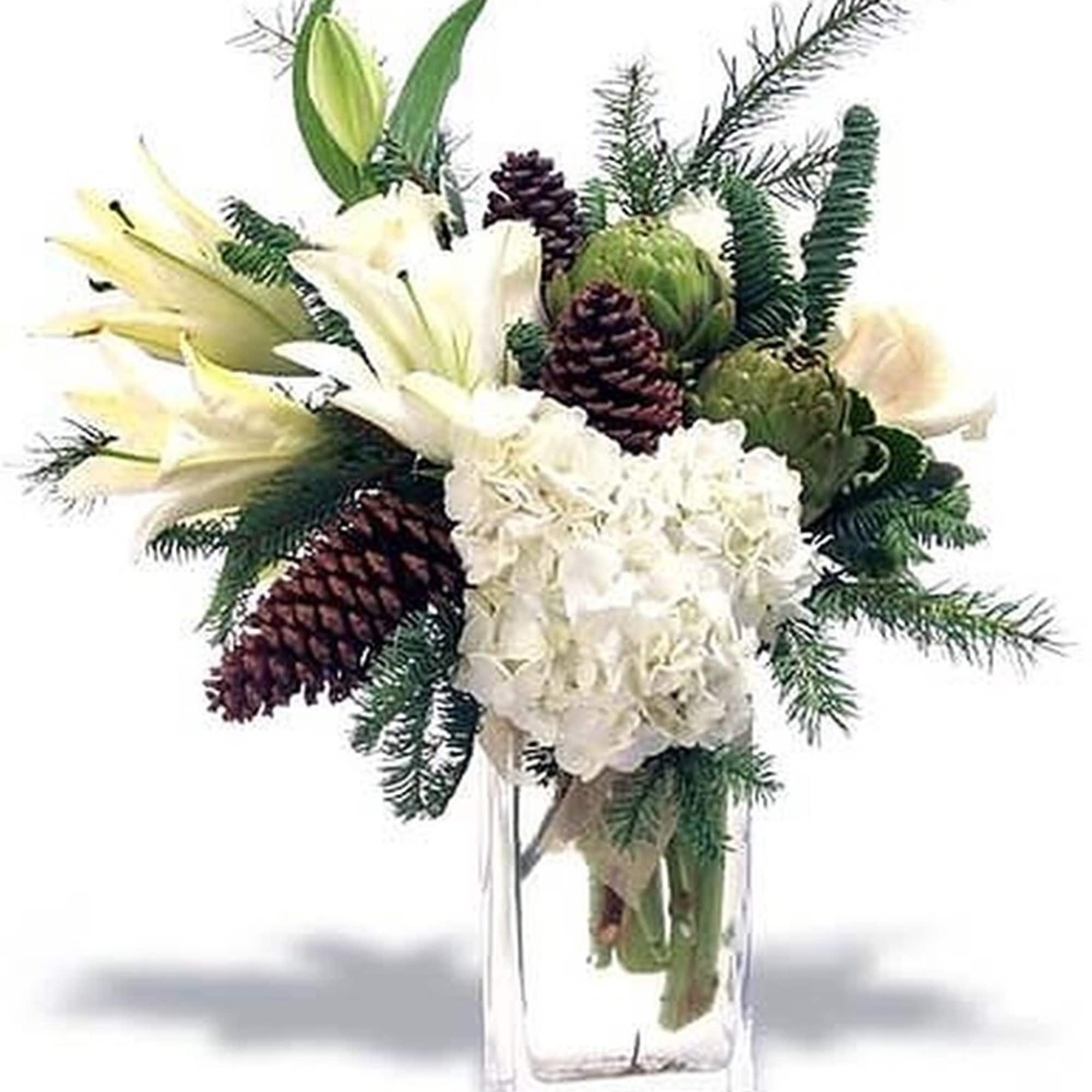 White lilies and hydrangea with pinecones and evergreens in a tall clear glass vase