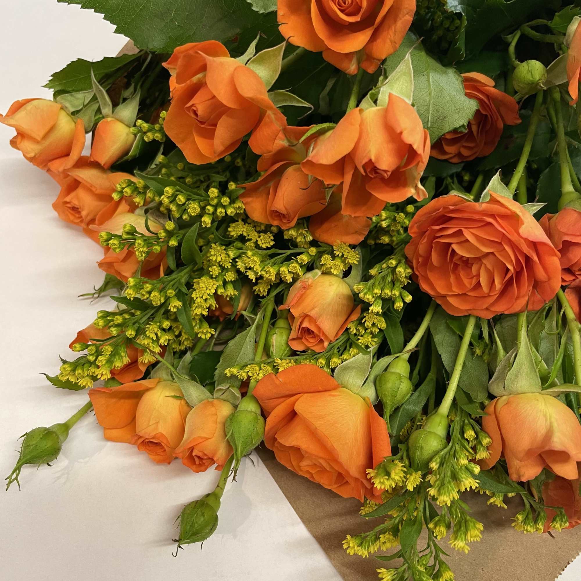 Bouquet of orange roses with yellow filler flowers
