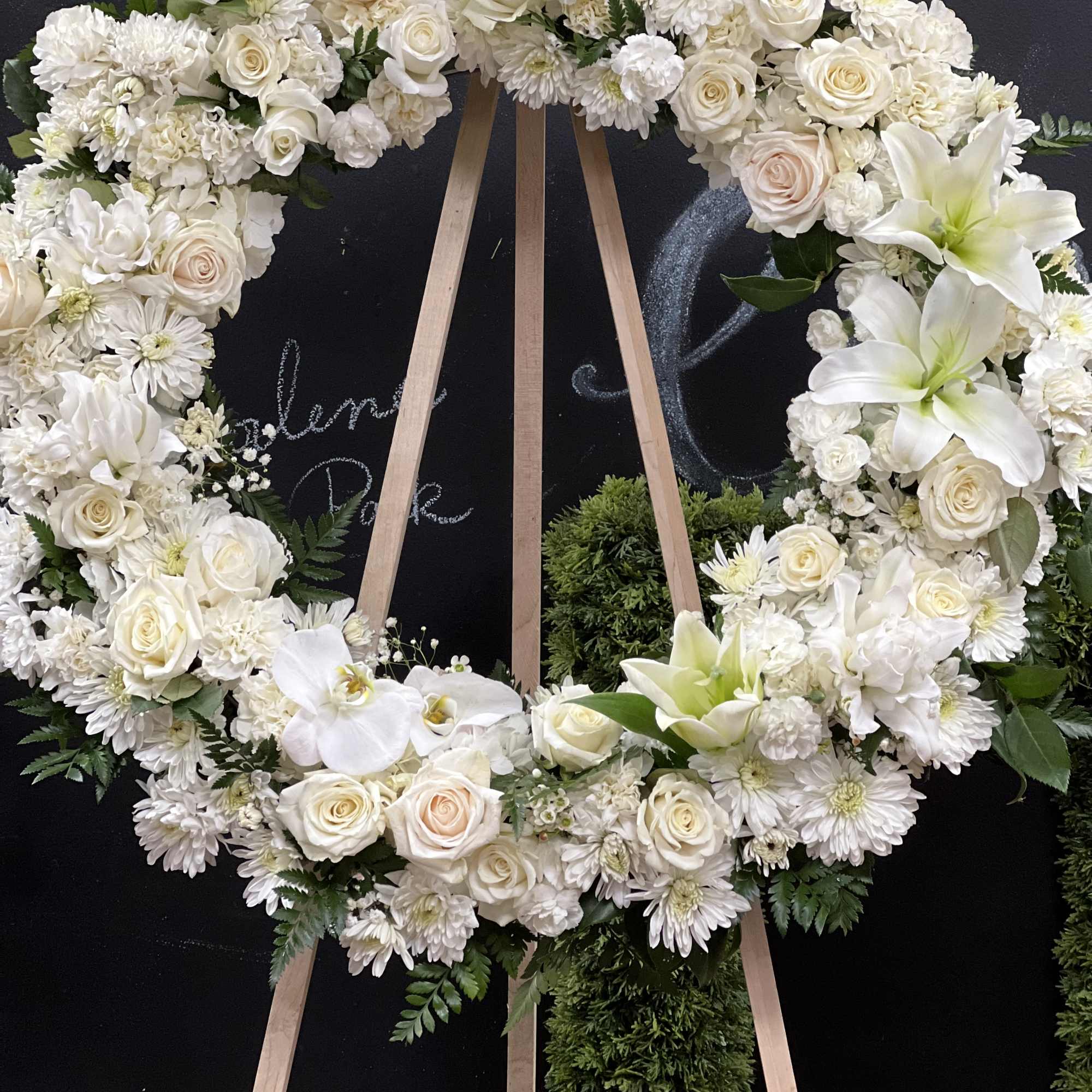White floral wreath on a wooden easel
