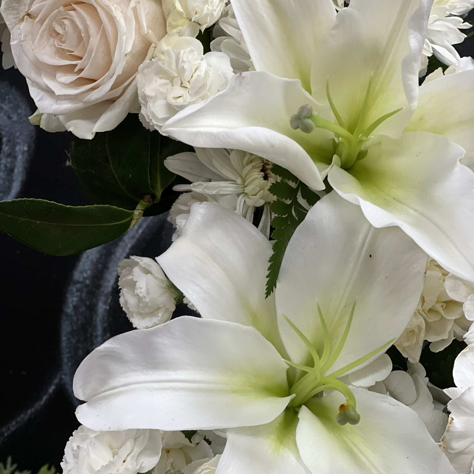 White lilies and pale roses in a close-up bouquet