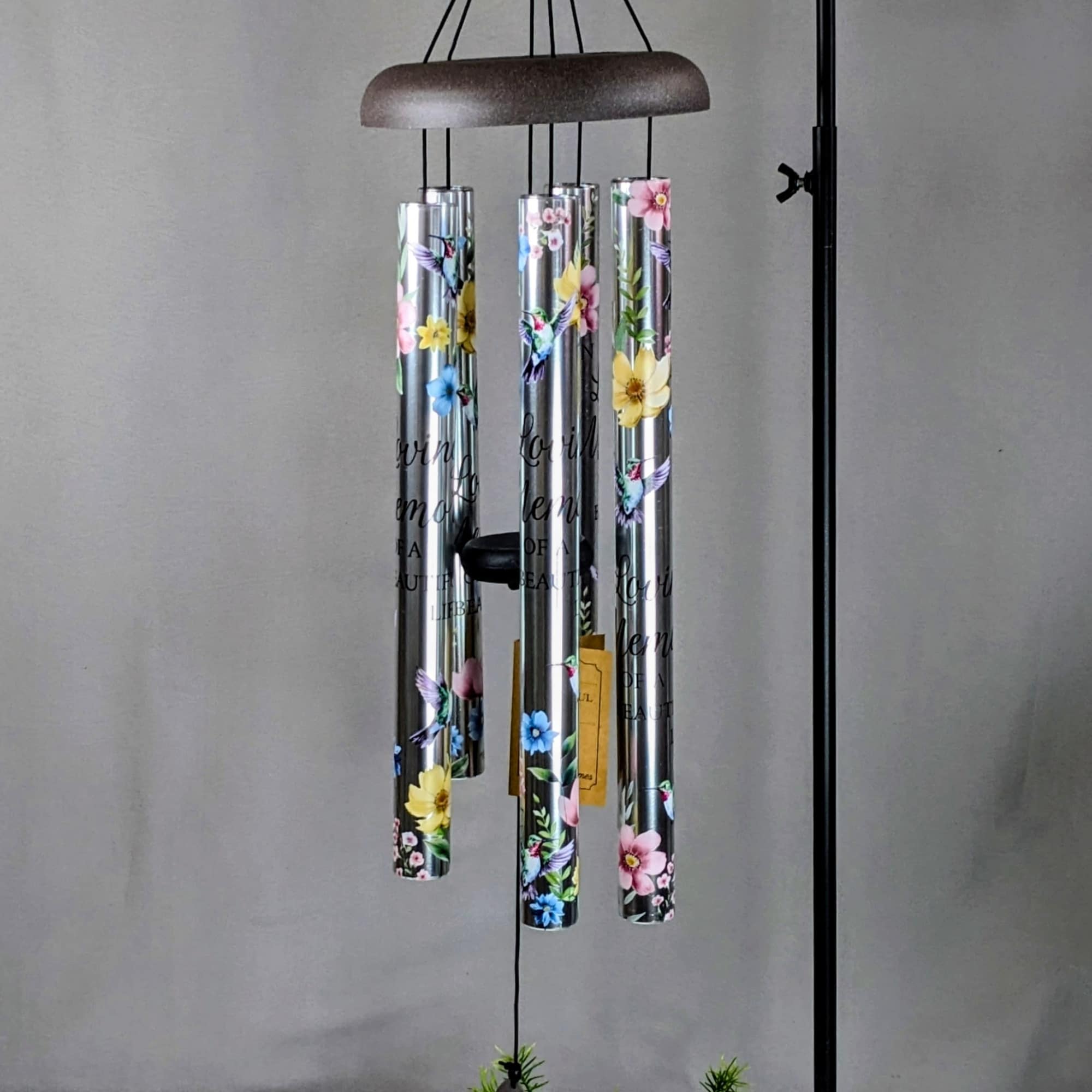 Hanging metal wind chime with floral-printed tubes and a leaf-shaped clapper