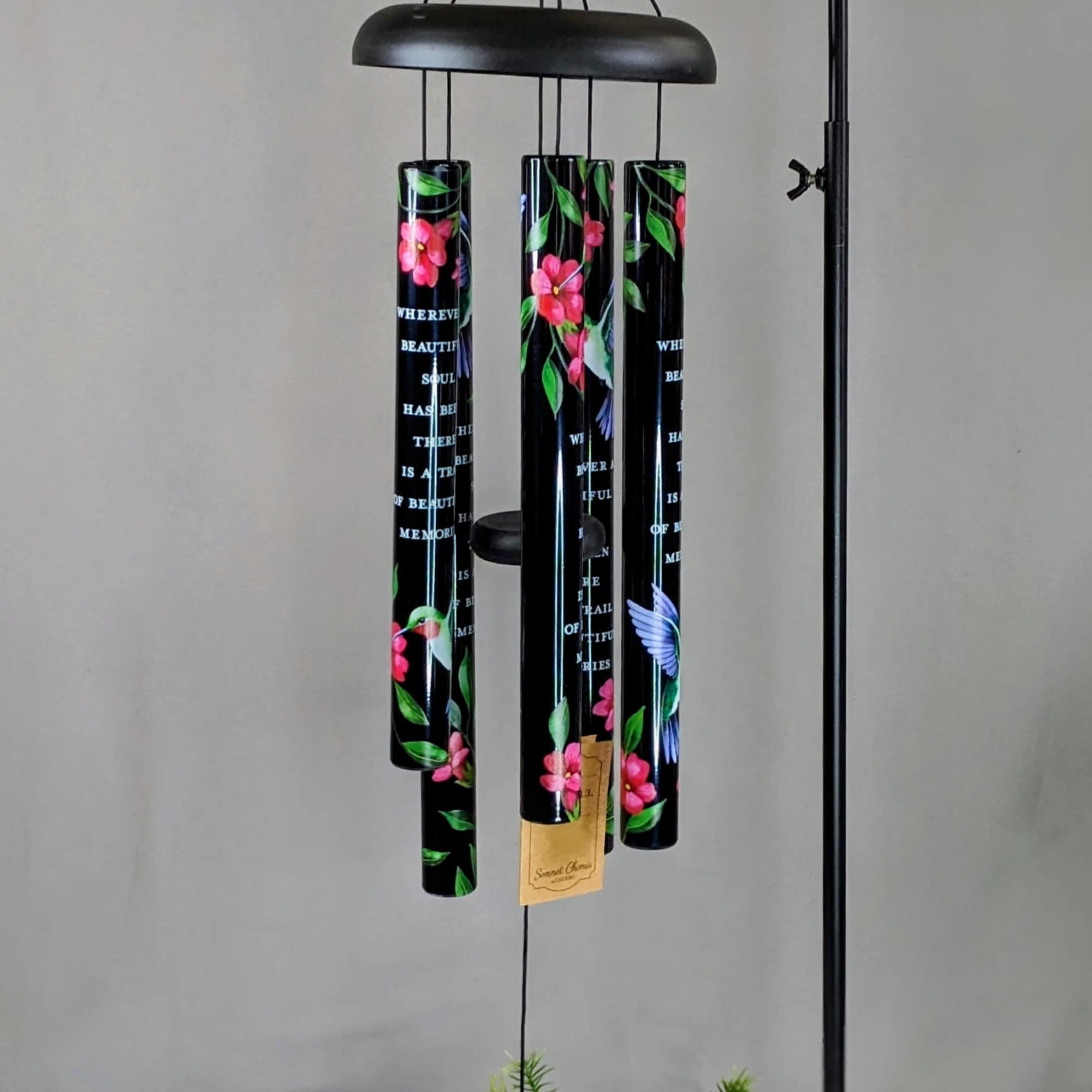 Black hanging wind chime with floral-painted tubes and a triangular striker