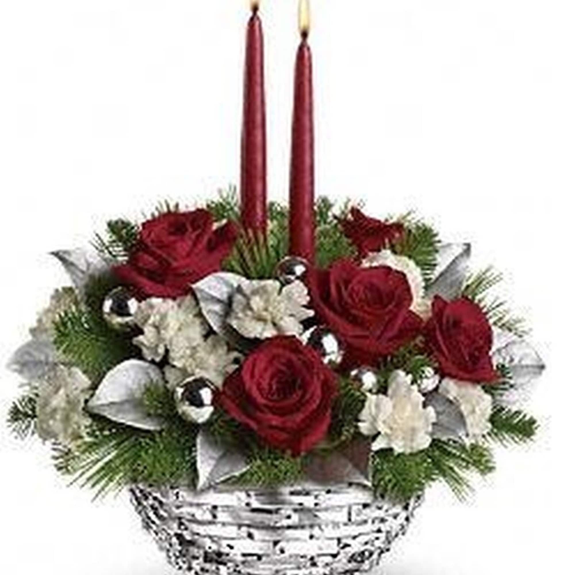 Red and white floral centerpiece with evergreens, silver accents, and two tall red candles in a white basket