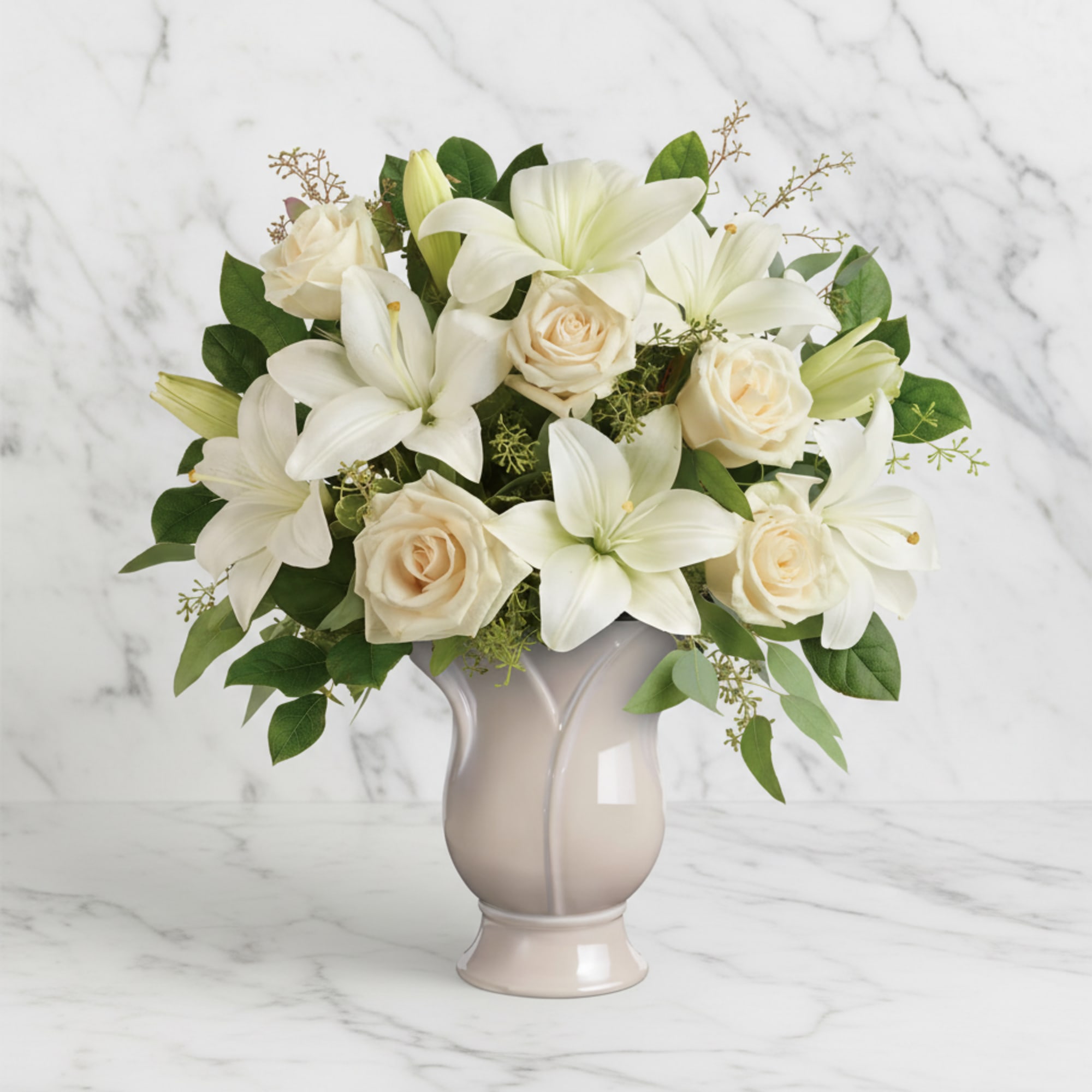 White lilies and cream roses arranged in a beige vase