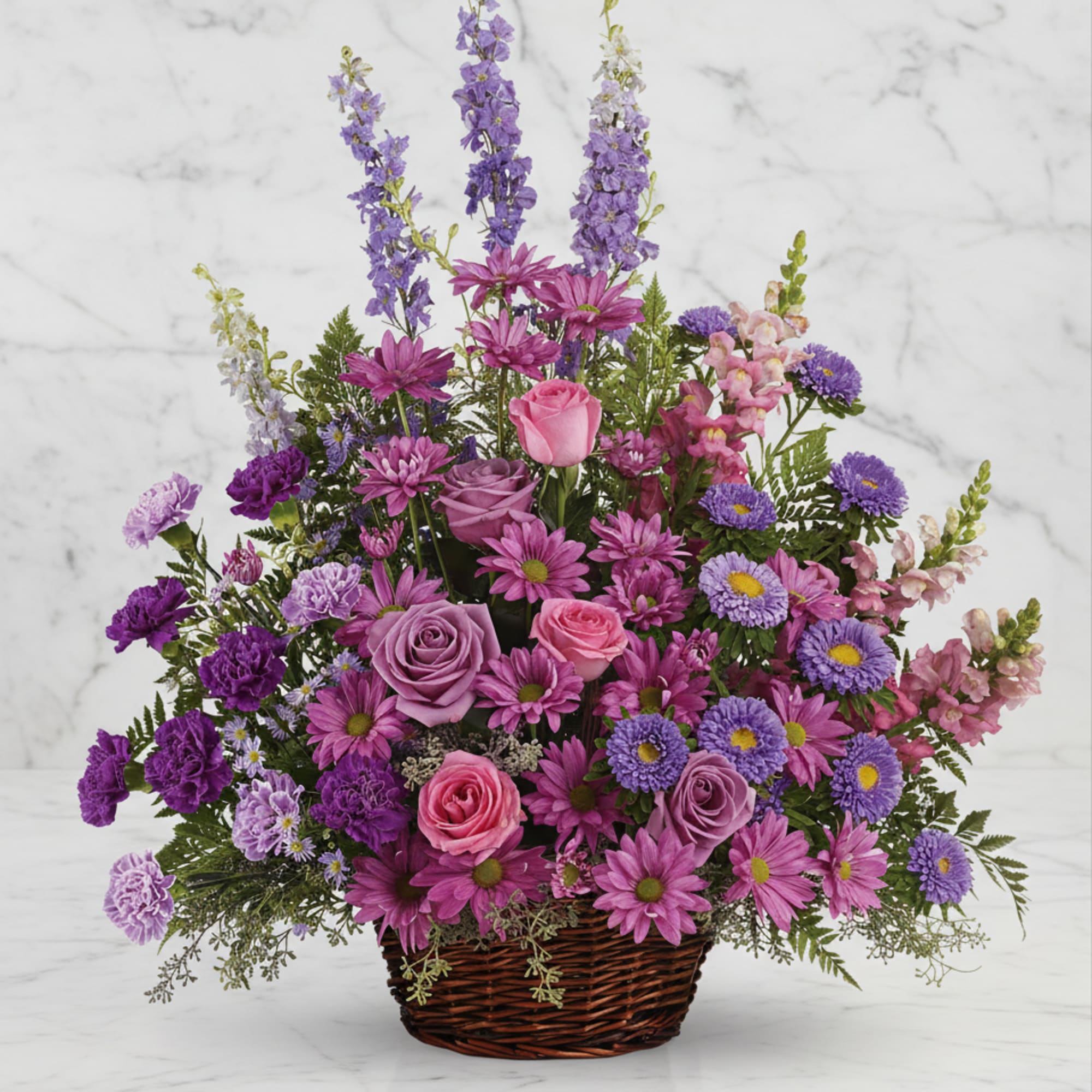 Basket arrangement of pink and purple flowers with tall lavender spikes