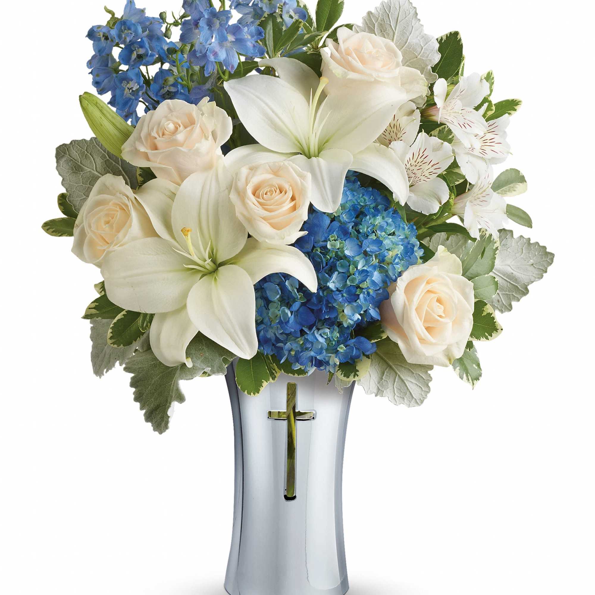 White lilies, cream roses, and blue flowers in a silver vase with a cross