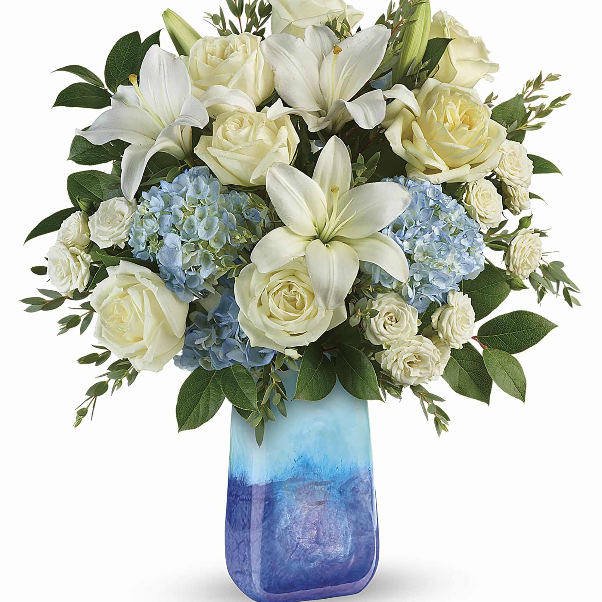 White roses, lilies, and blue hydrangeas in a blue glass vase