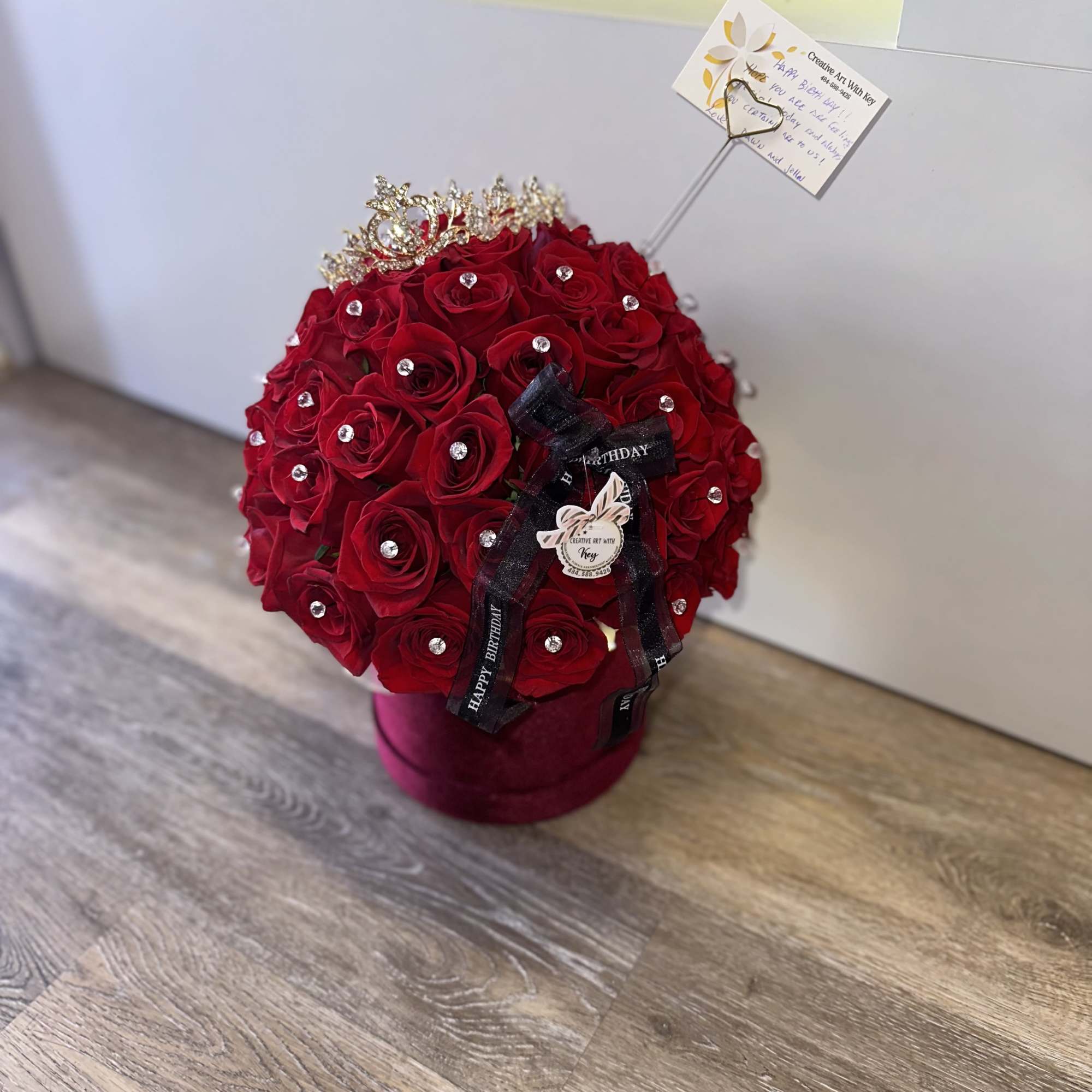 Red rose arrangement in a velvet box with a tiara and ribbon
