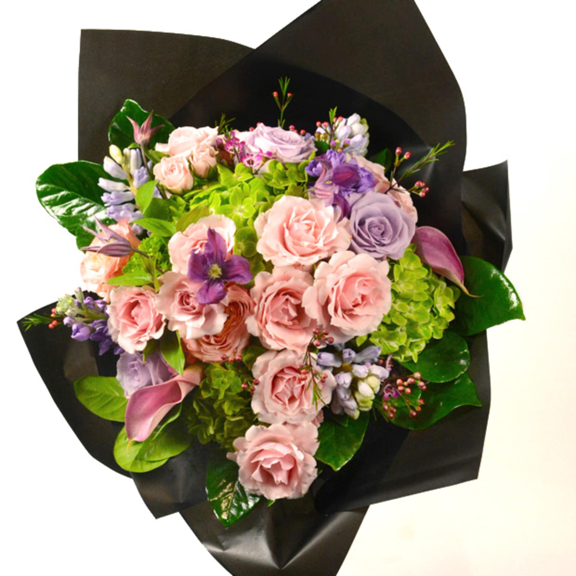 Bouquet of pink and lavender roses with purple accents wrapped in black paper
