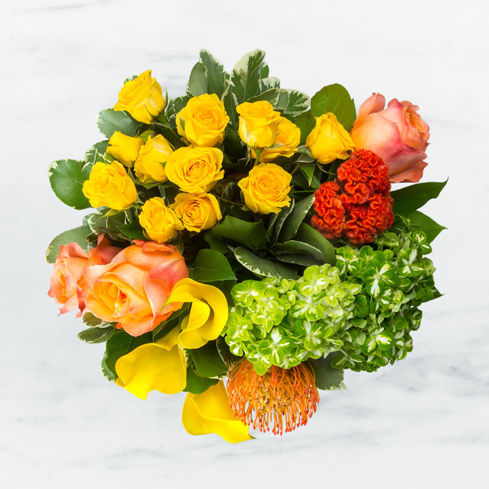 Bouquet of yellow roses, peach roses, and green hydrangeas with orange accents