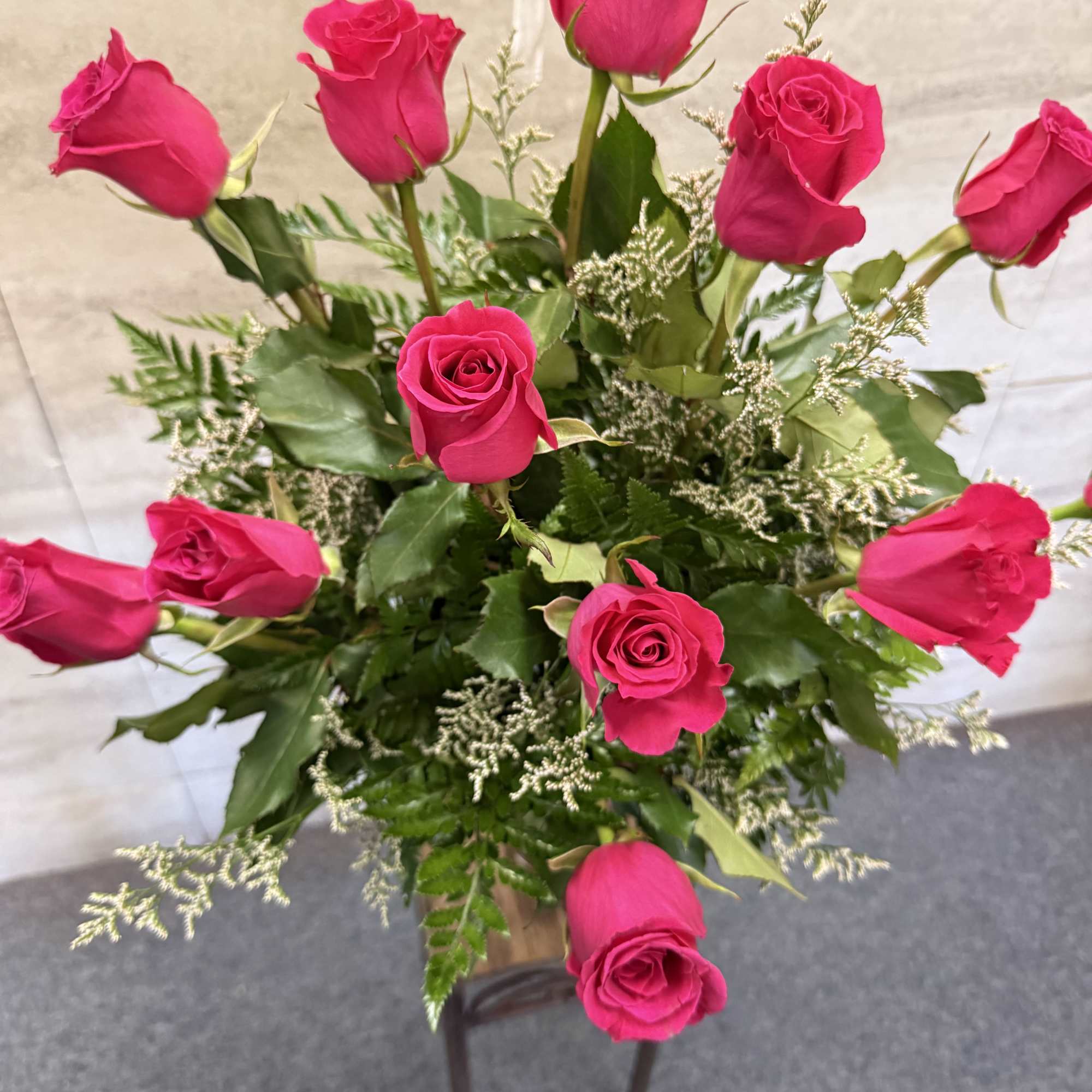 Bouquet of hot pink roses with greenery in a vase