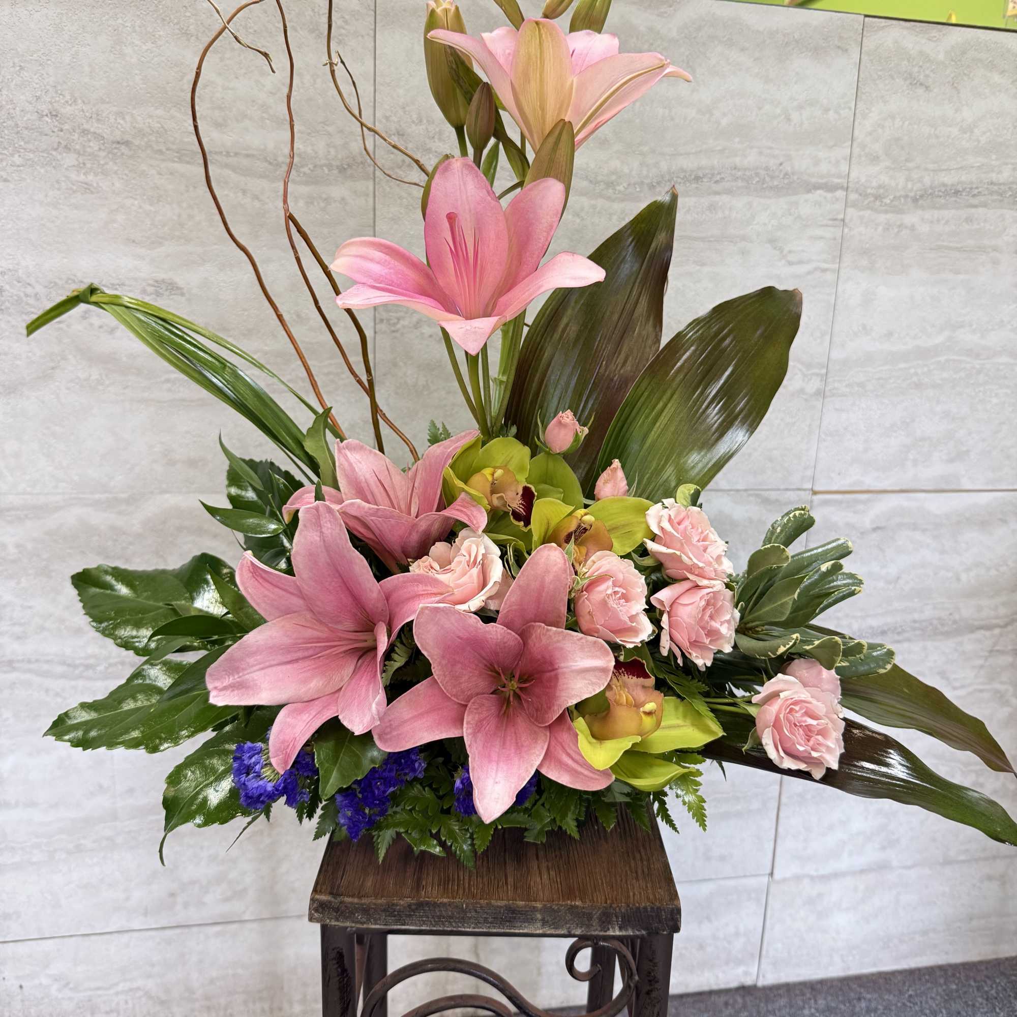 (ONE-SIDED) The exotic bouquet includes pink cymbidium orchids, light pink spray roses