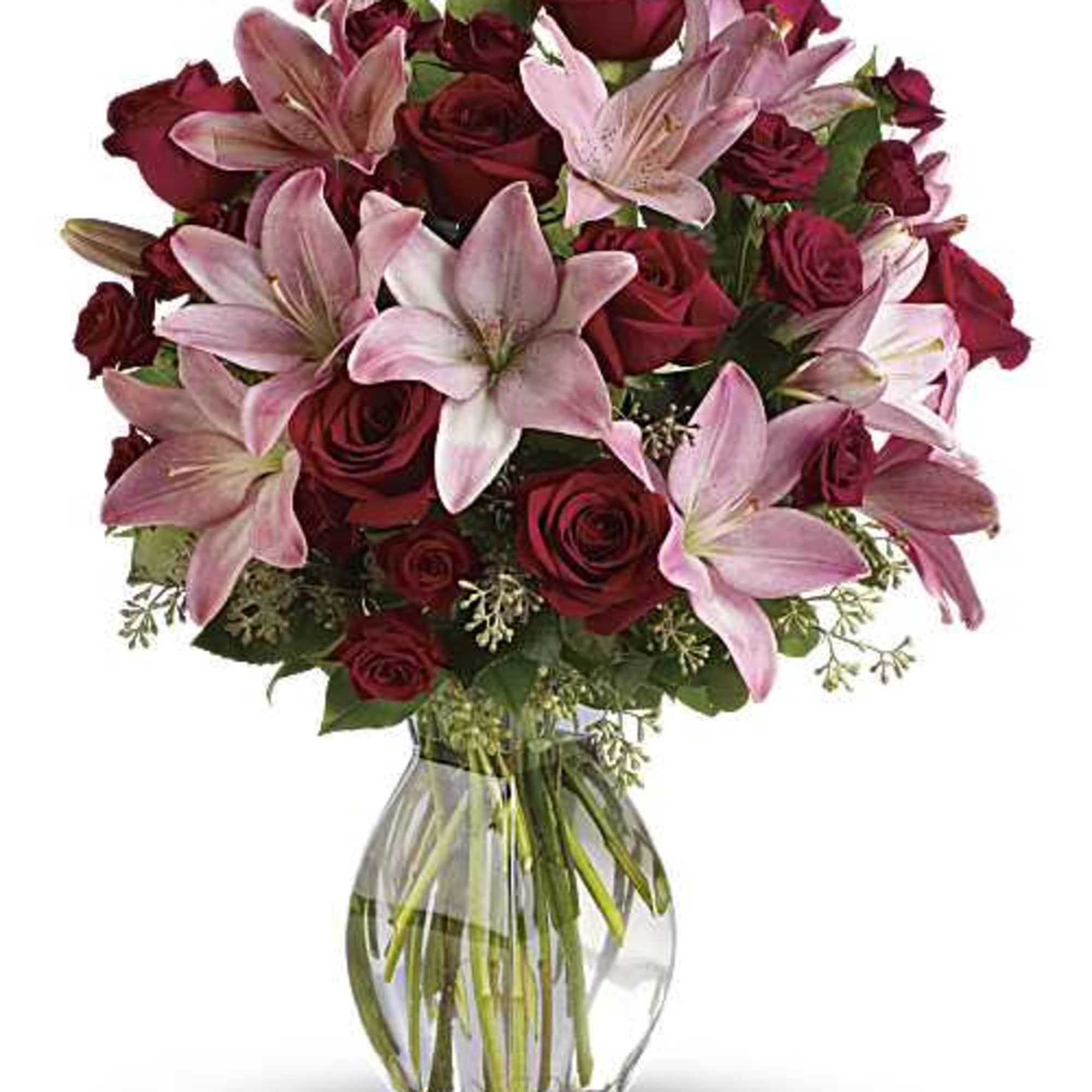 Arrangement of red roses and pink lilies in a clear glass vase