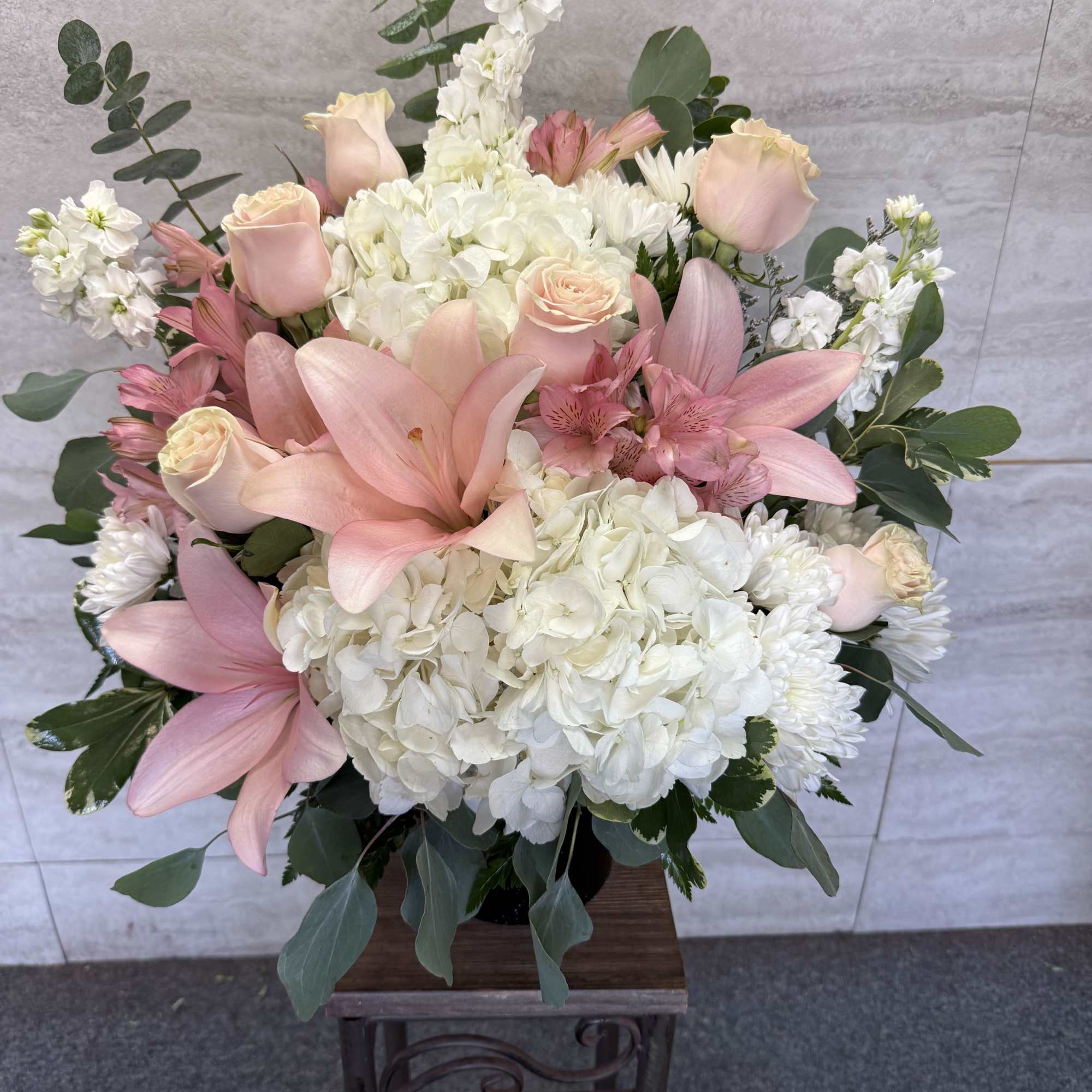 Pink lilies and roses with white hydrangeas in a vase