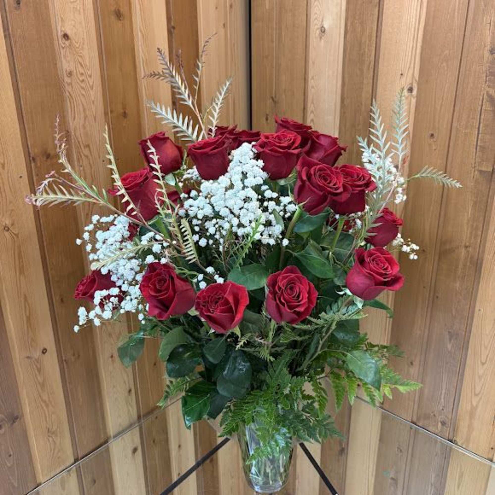 Velvety long-stemmed red roses arranged with delicate white filler create a timeless