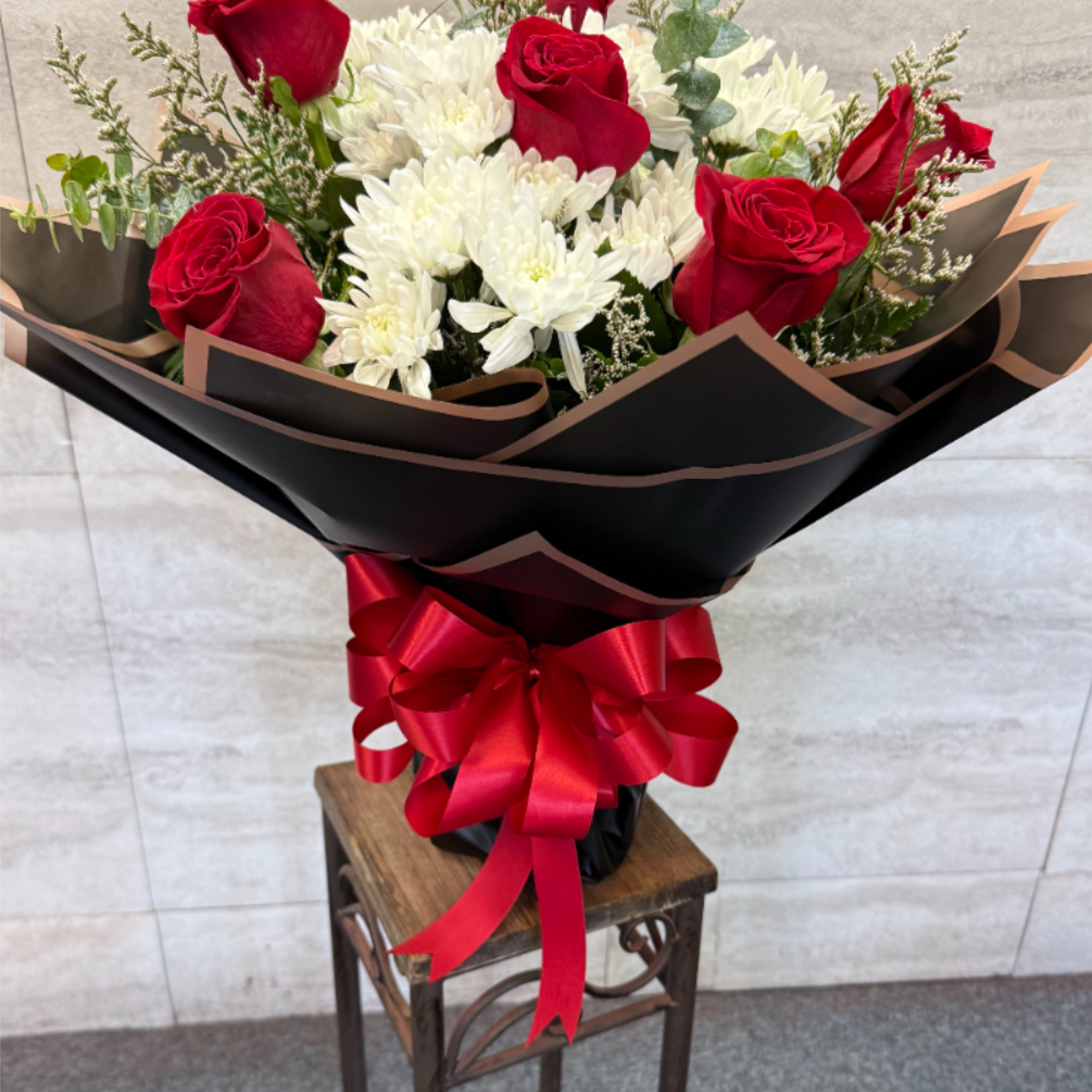 (WRAP- NO VASE) Red roses and soft white blooms with greenery, wrapped