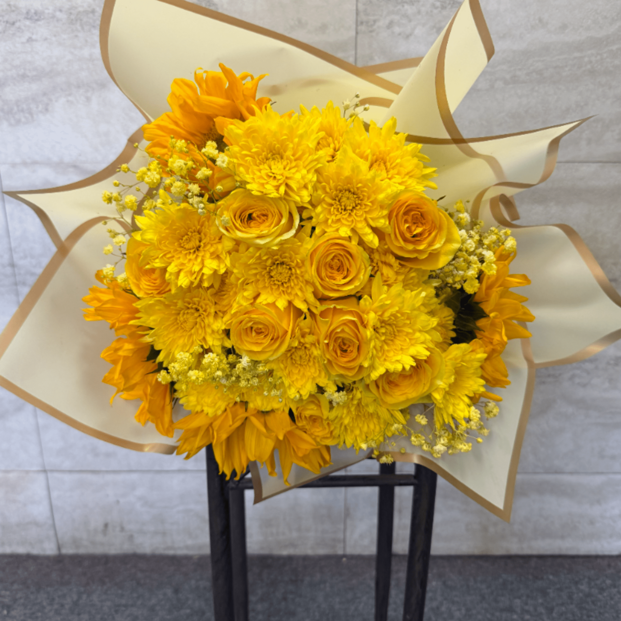 (WRAP-NO VASE) A wrapped bouquet filled with yellow florals, perfect for celebrating