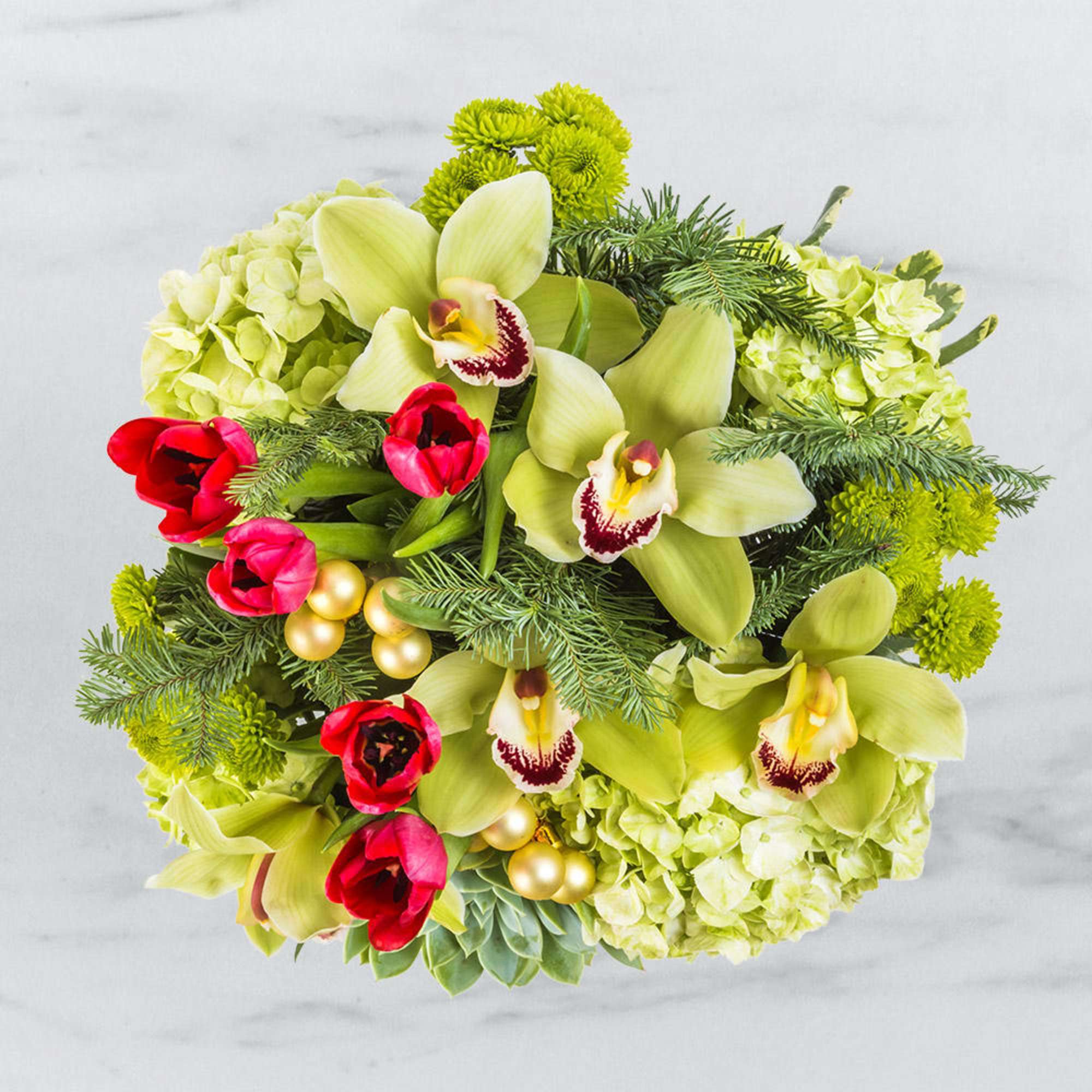 Bouquet of green orchids, red tulips, and lime hydrangeas with evergreen accents