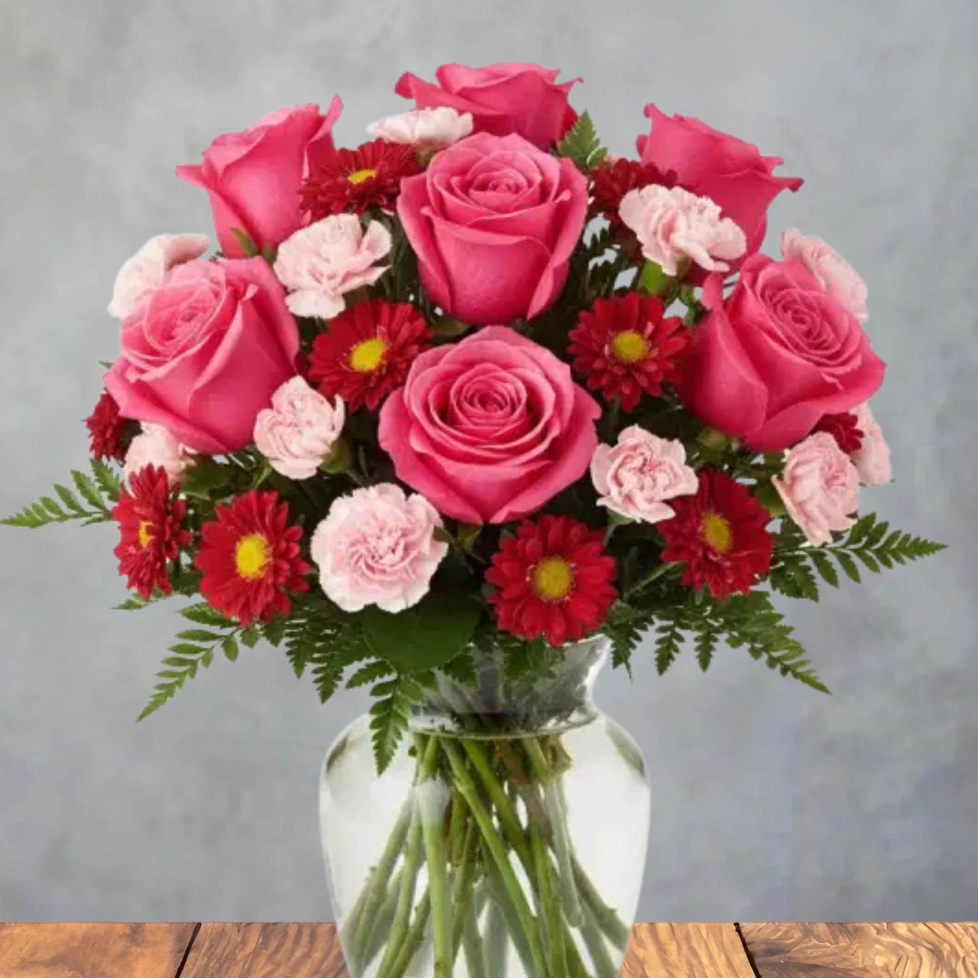 Bright pink roses take center stage in this cheerful, romantic flower arrangement-perfect