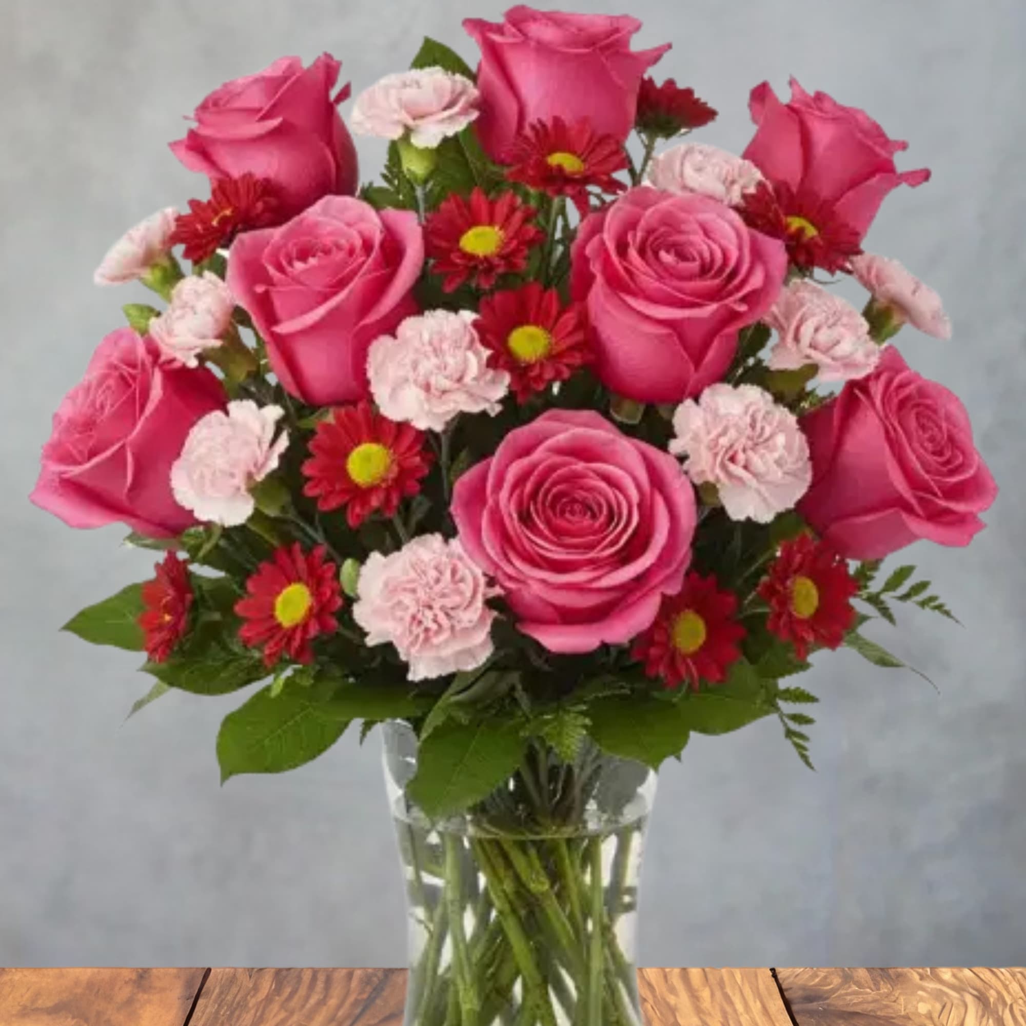 Bright pink roses take center stage in this cheerful, romantic flower arrangement-perfect