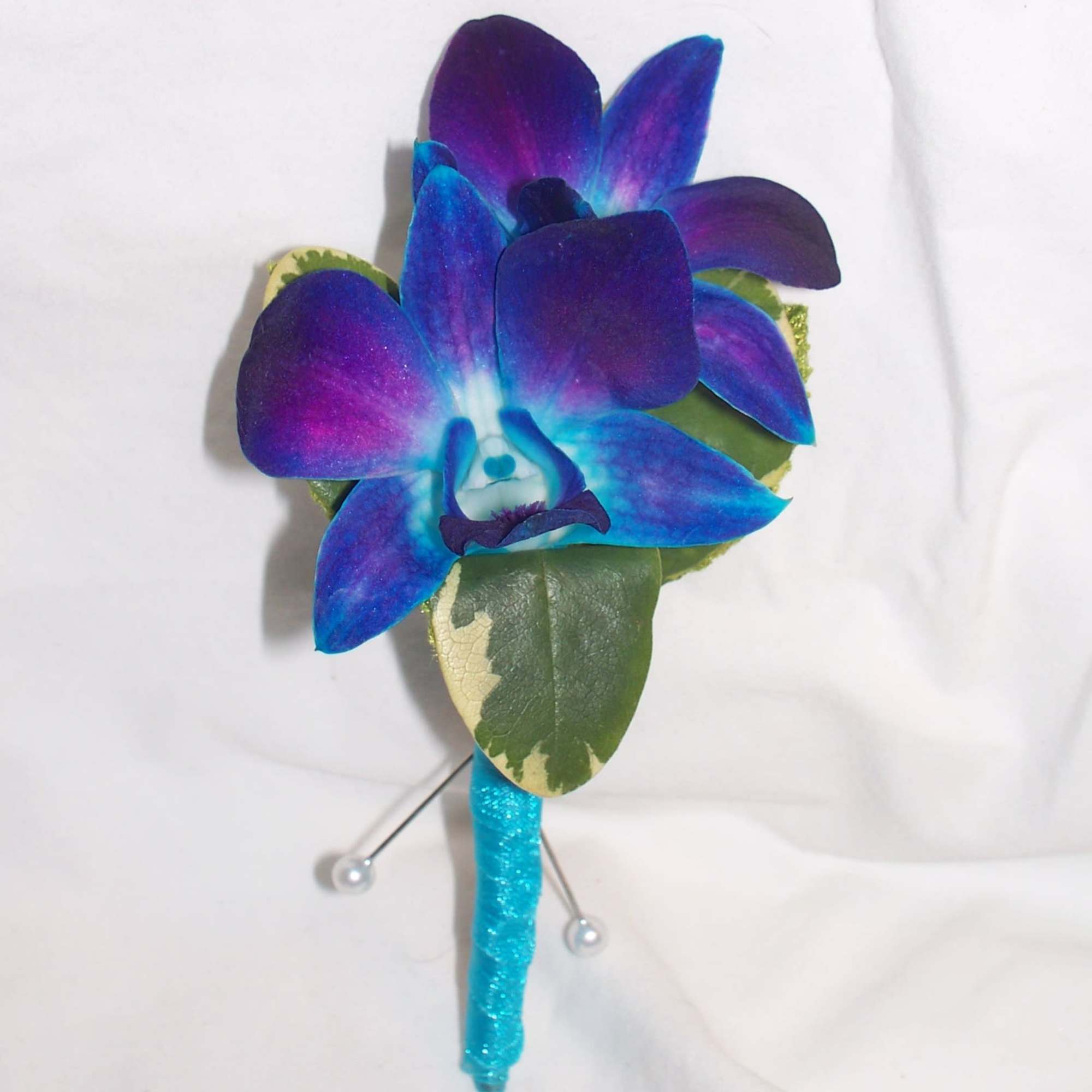 Blue and purple orchid boutonniere with a glittery turquoise stem wrap