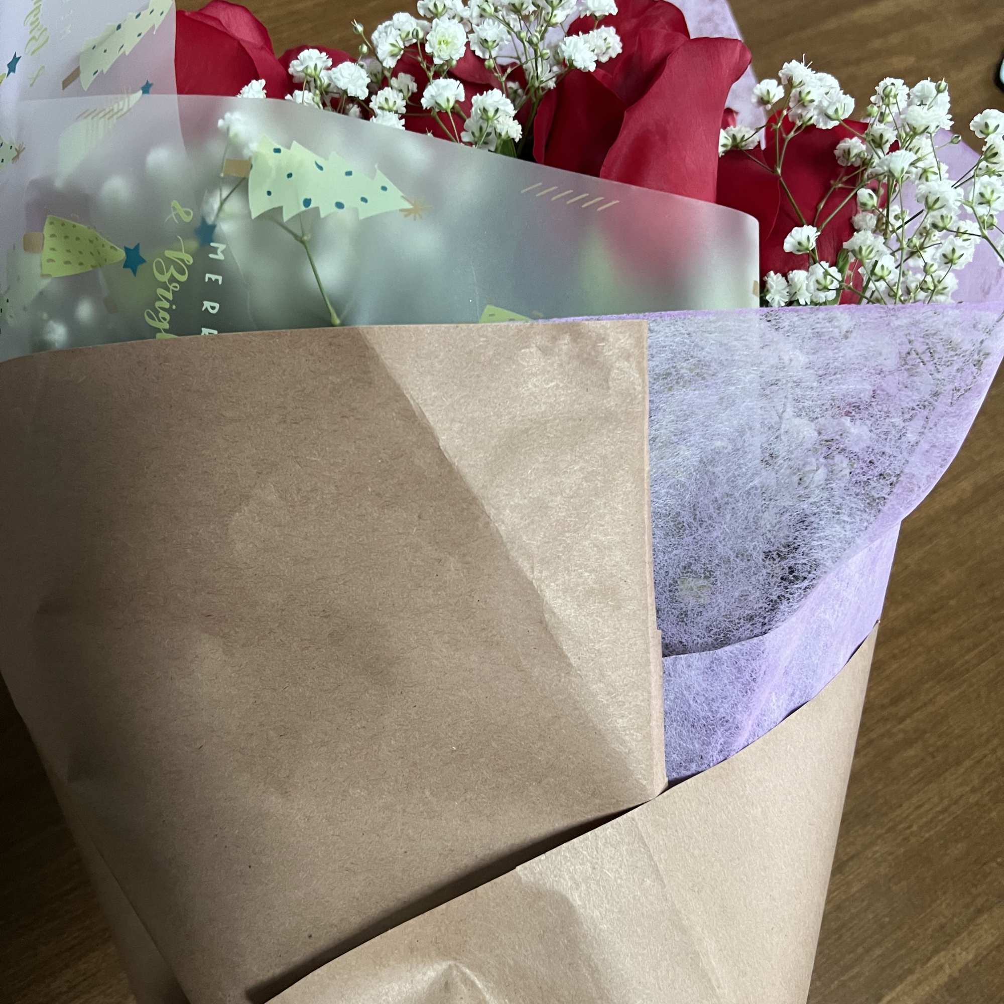 Bouquet of red roses with white baby's breath in wrapped paper