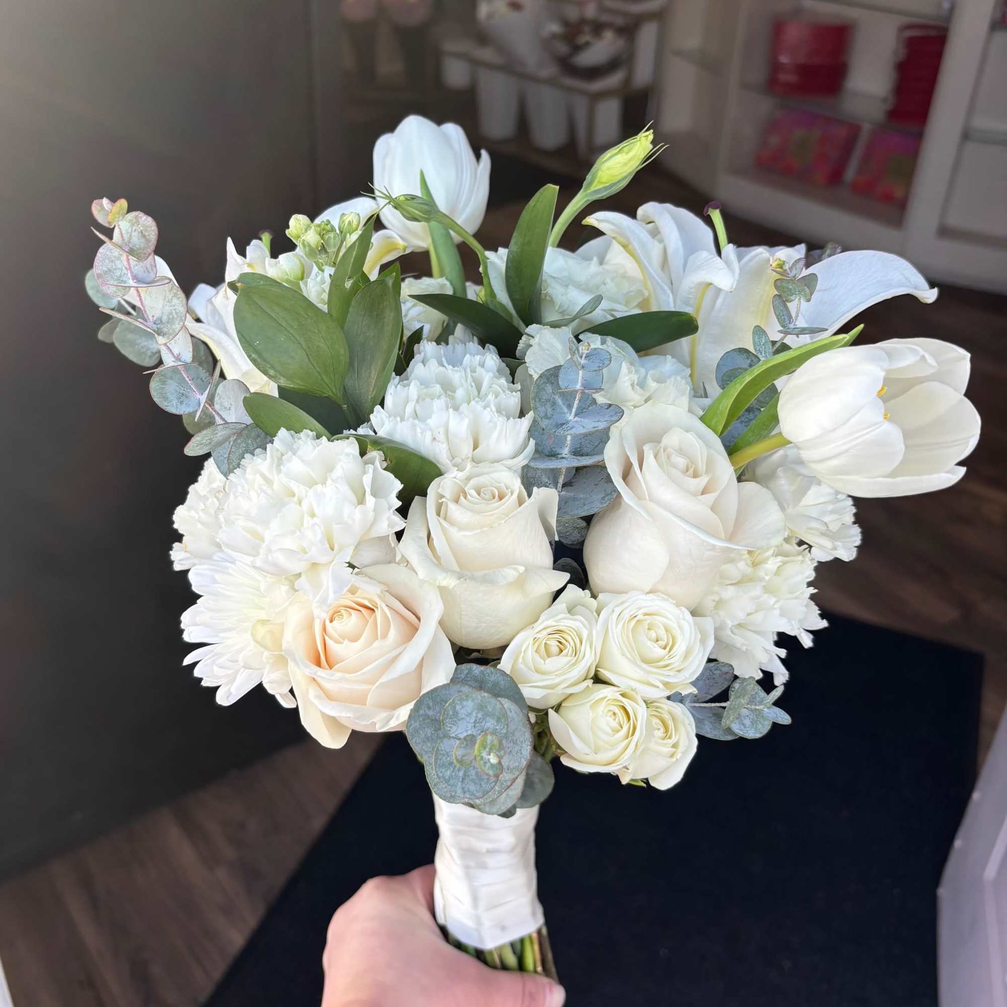 White bouquet with roses, lilies, carnations, and eucalyptus