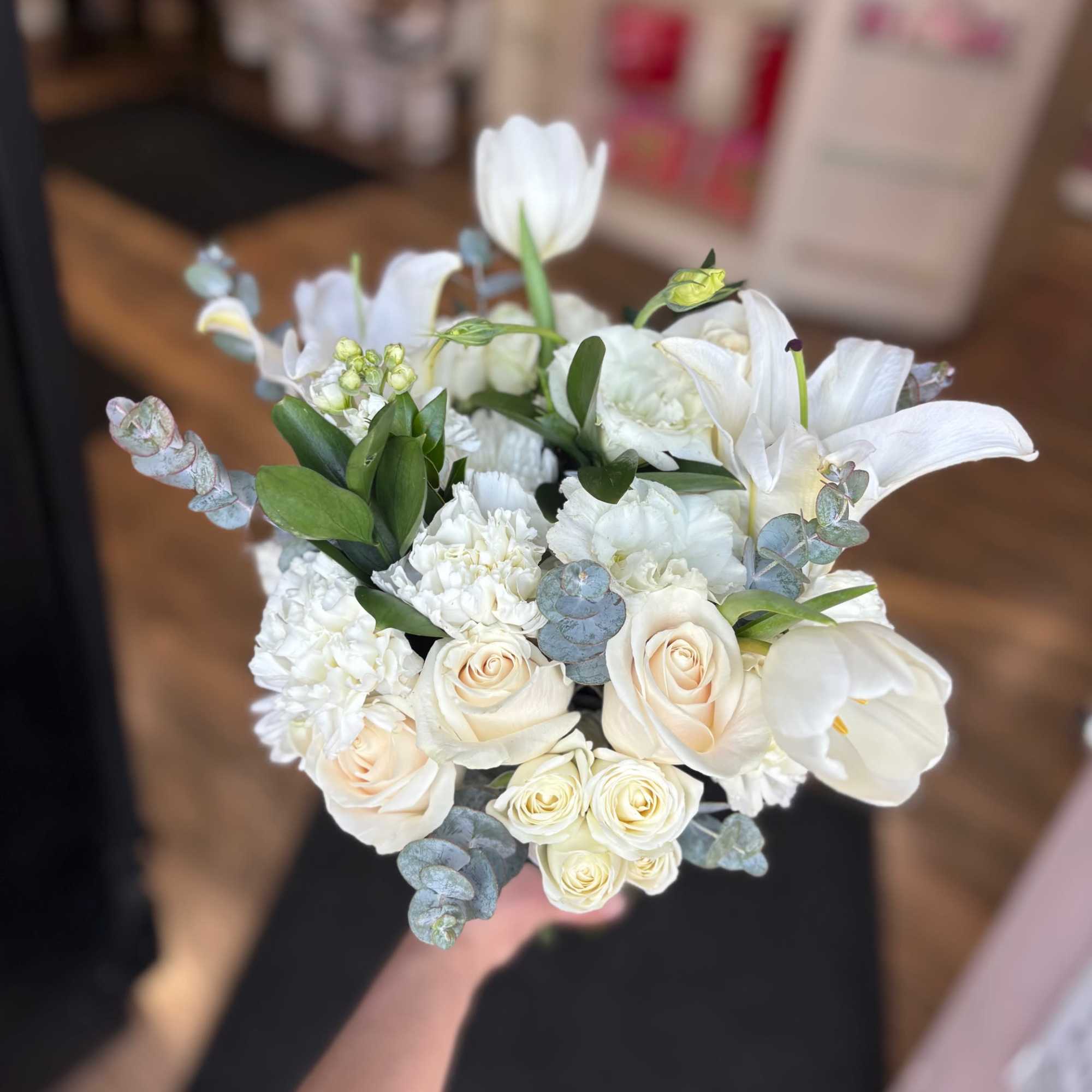 White bouquet with roses, lilies, and eucalyptus